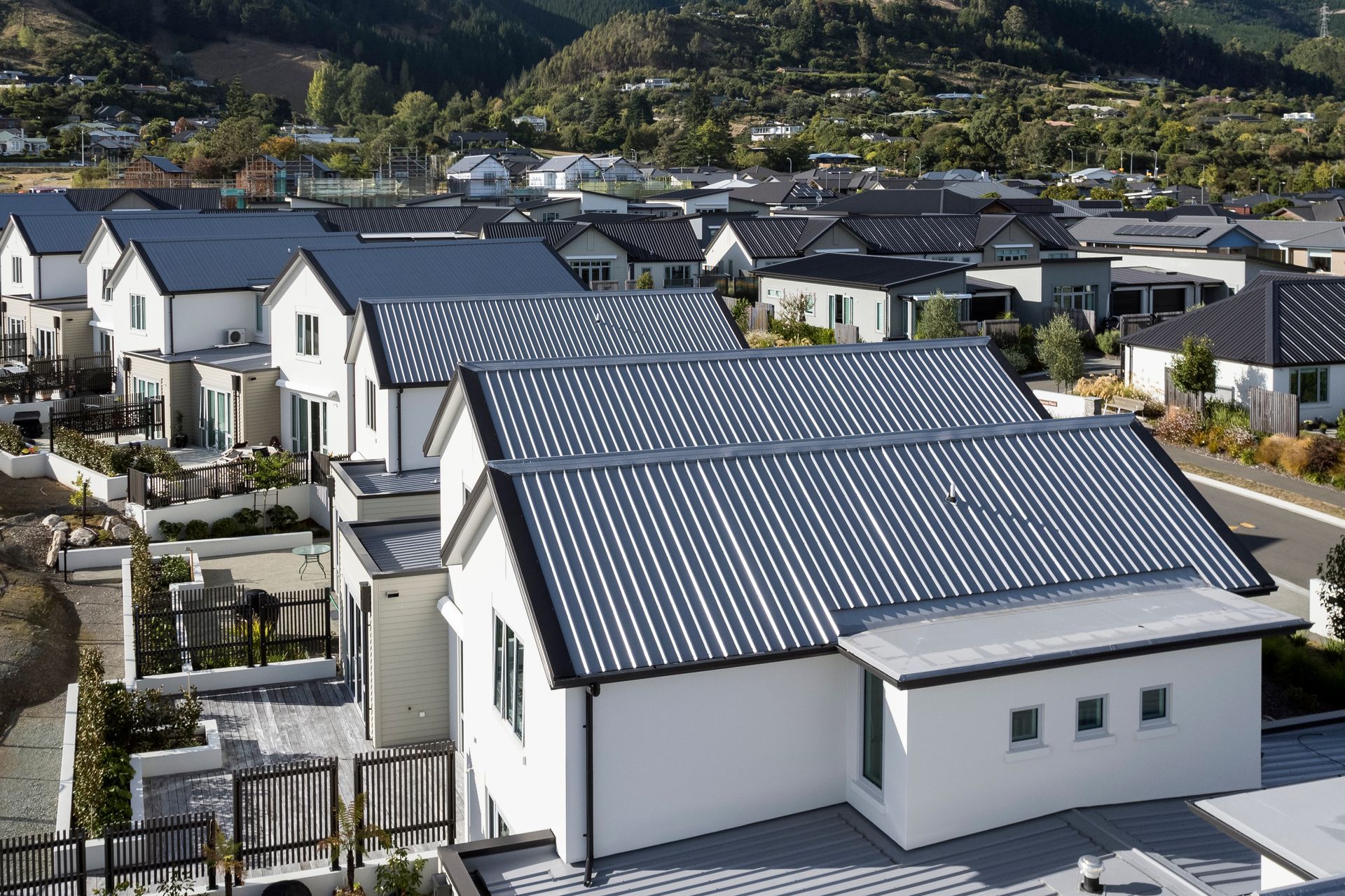 An aerial view of a row of houses with solar panels on the roofs.