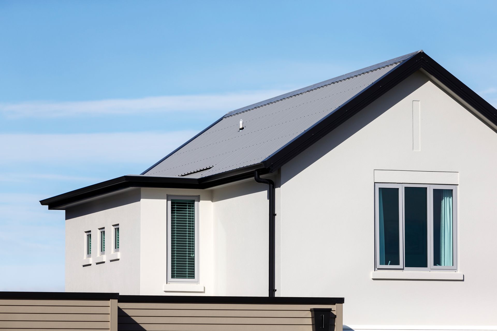 A white house with a black roof and windows