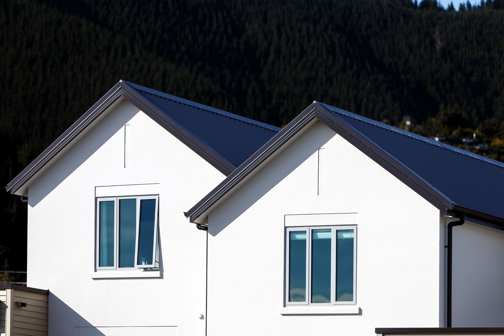A white house with a blue roof and two windows
