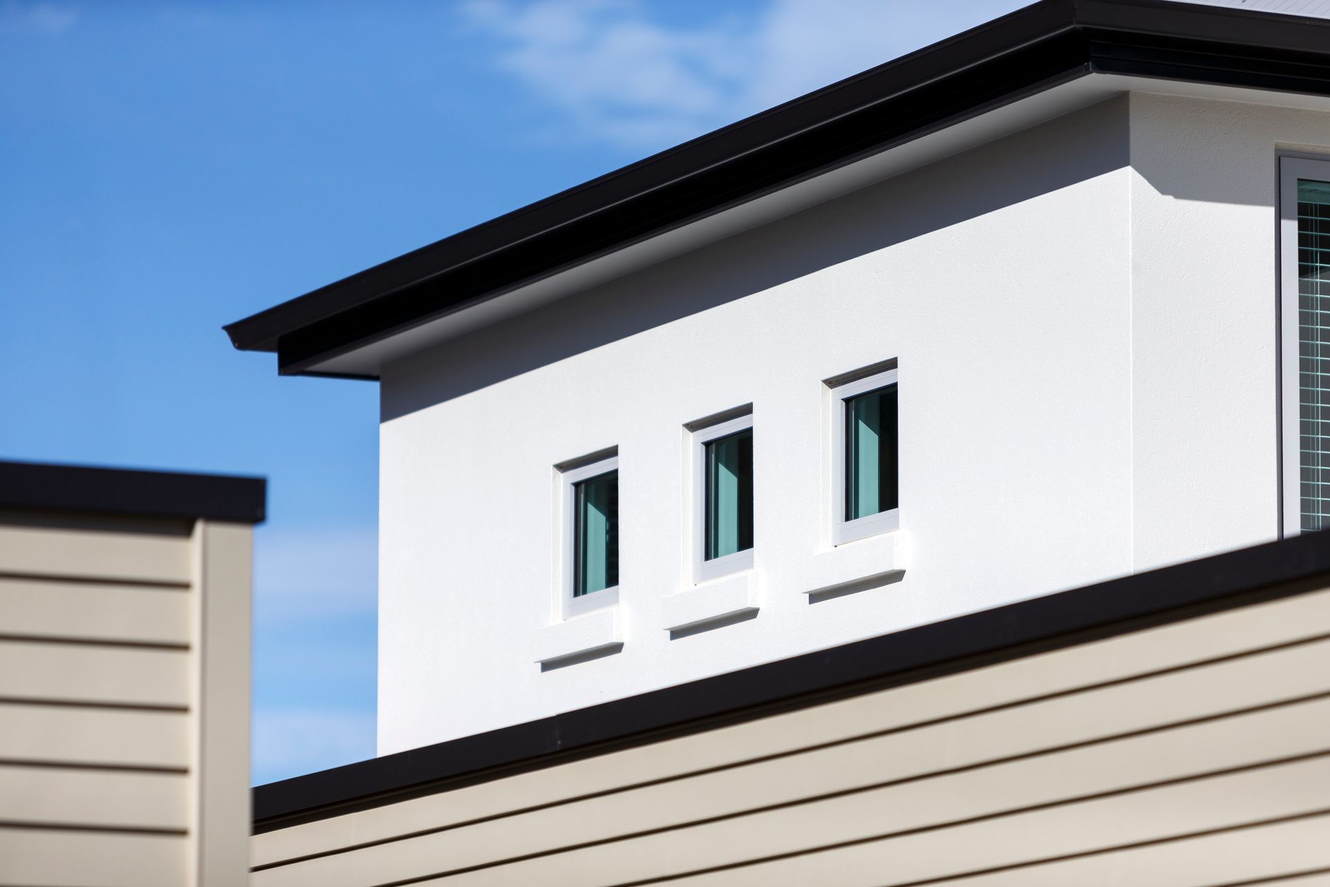 A white building with three windows on the top of it