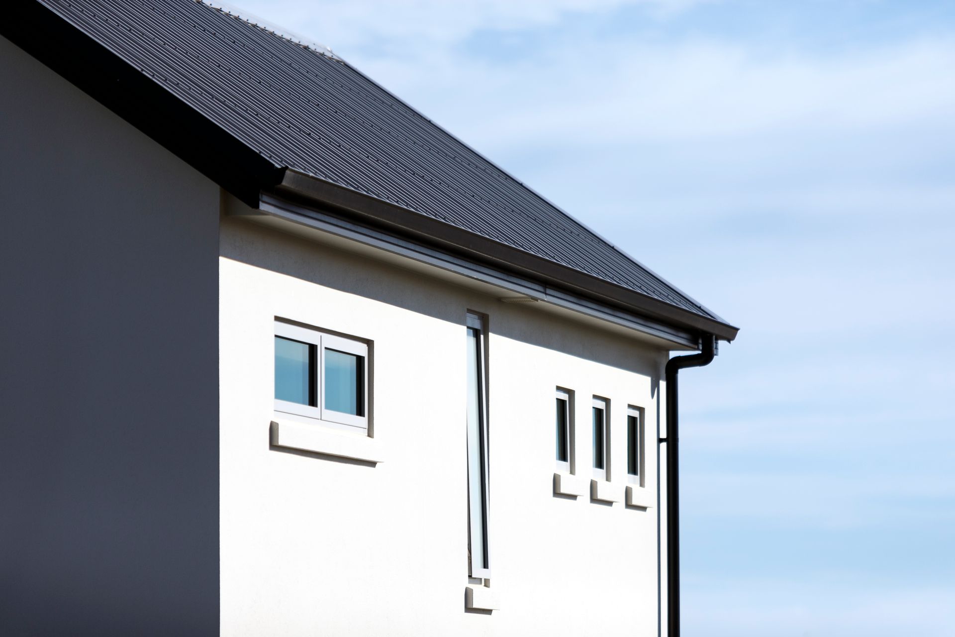 A white house with a black roof and windows