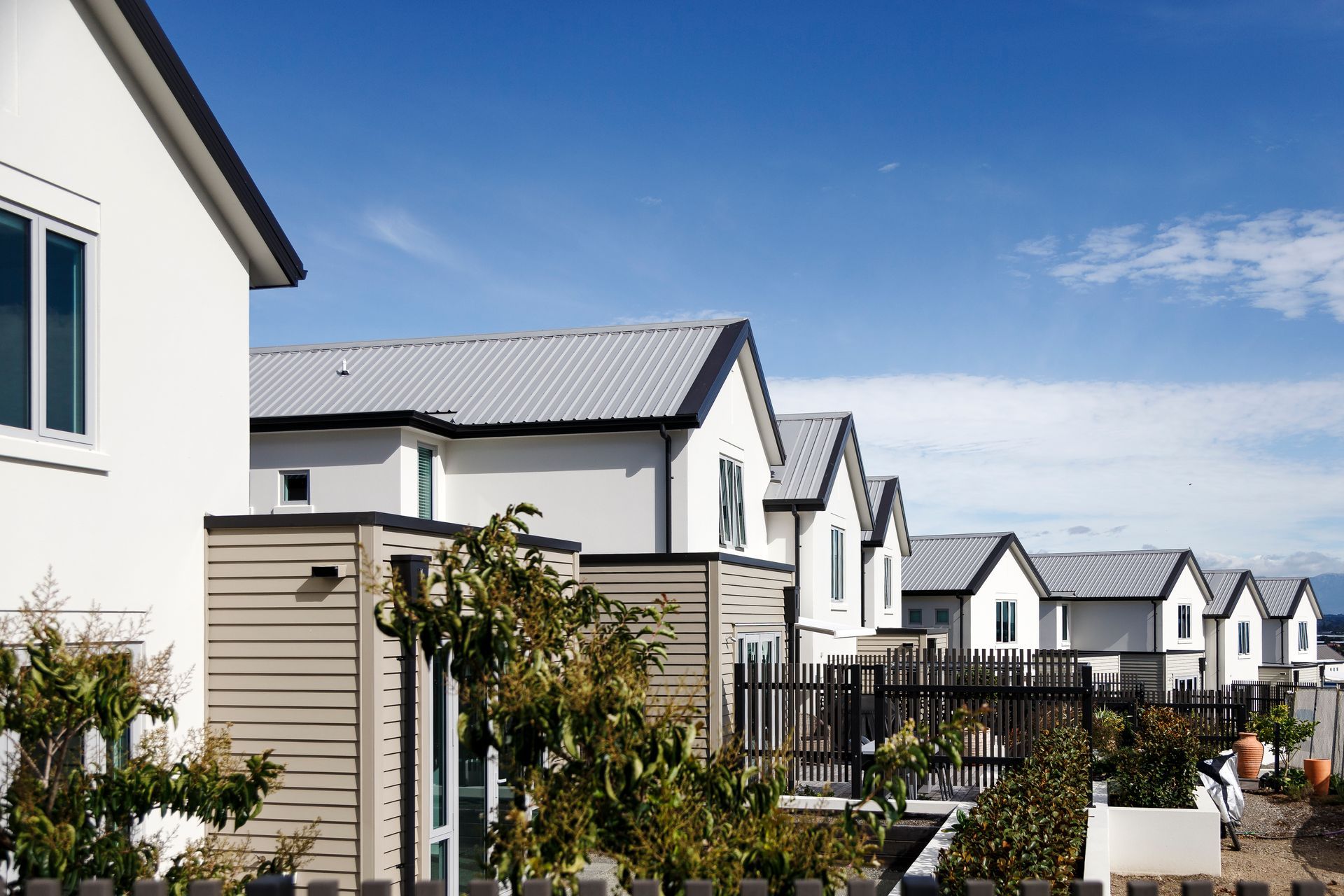 A row of houses with a blue sky in the background