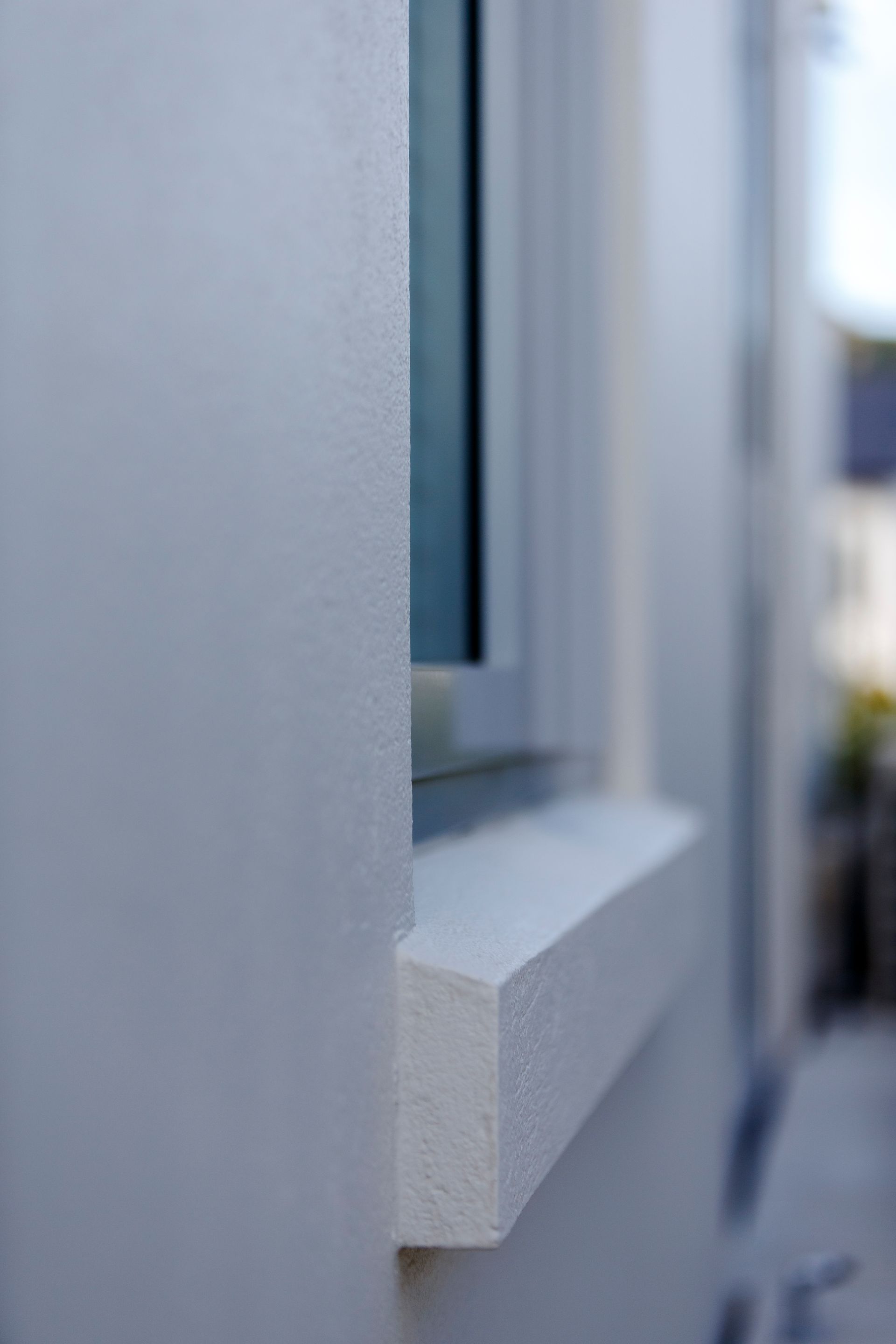 A close up of a window on a white wall.