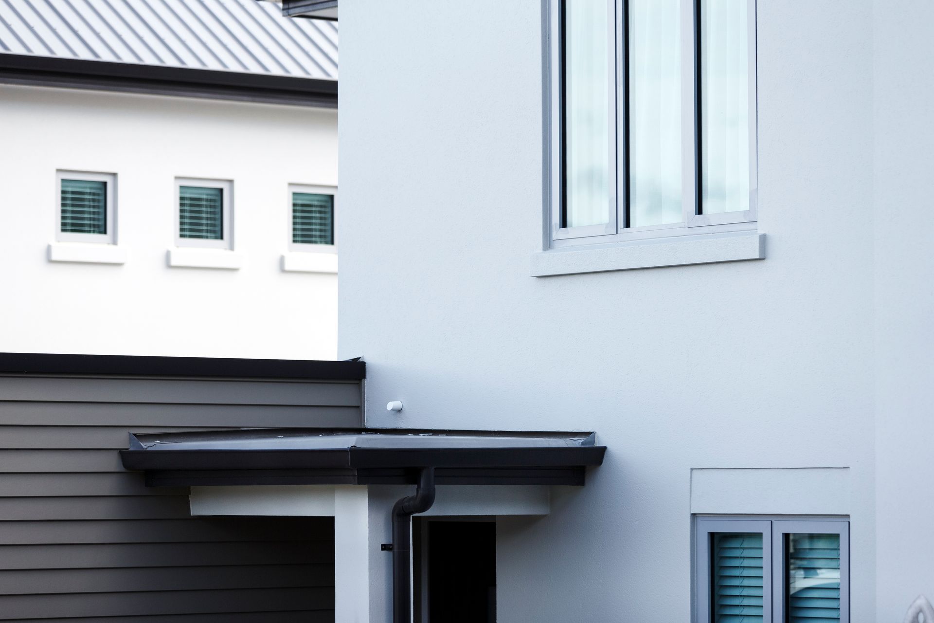 A white house with a garage and three windows