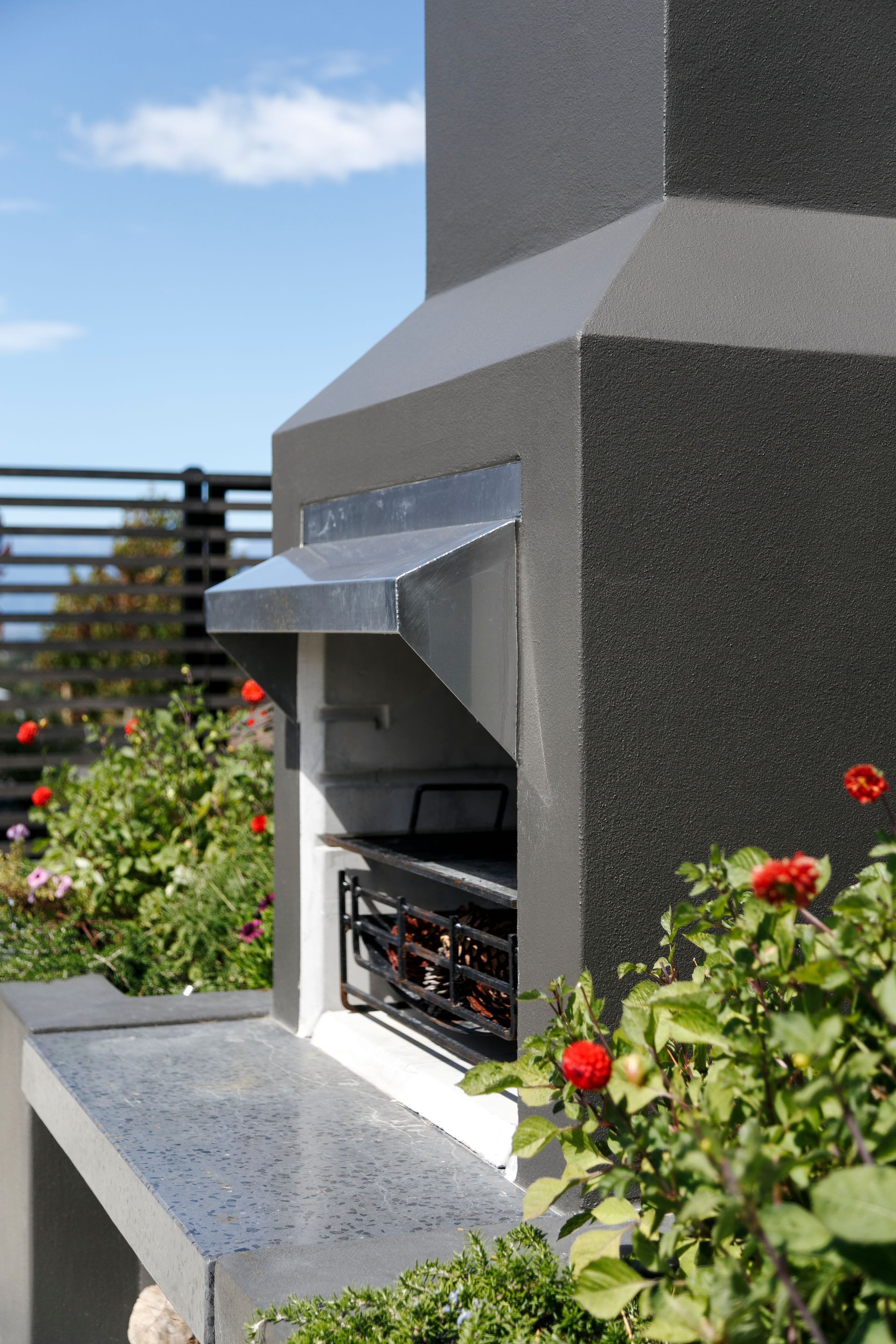 A bbq grill is built into the side of a building