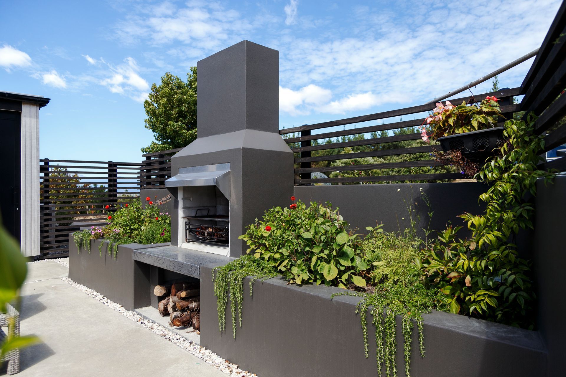A patio with a fireplace and a shed in the background