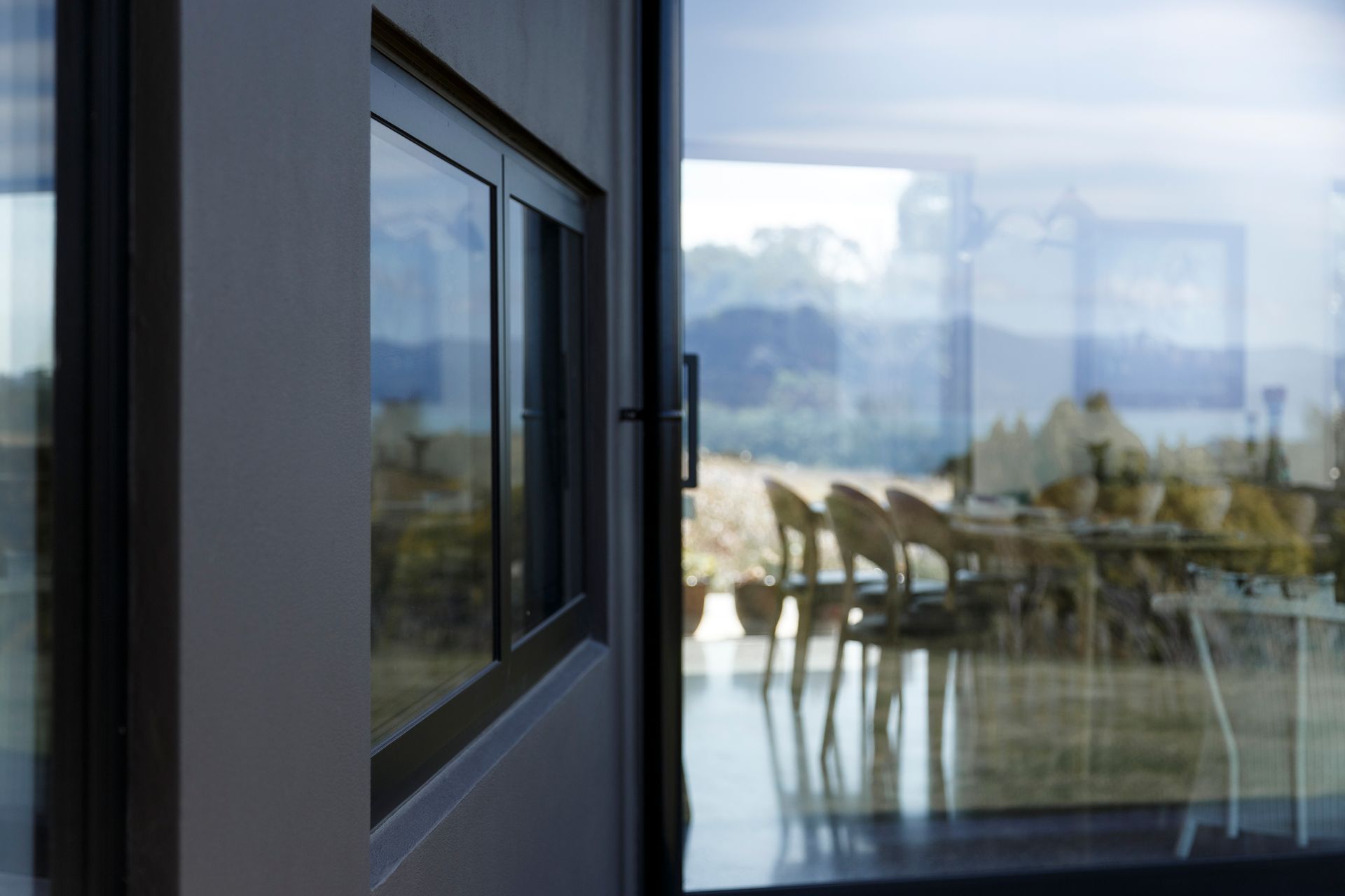 A window with a view of a dining table and chairs in a house.