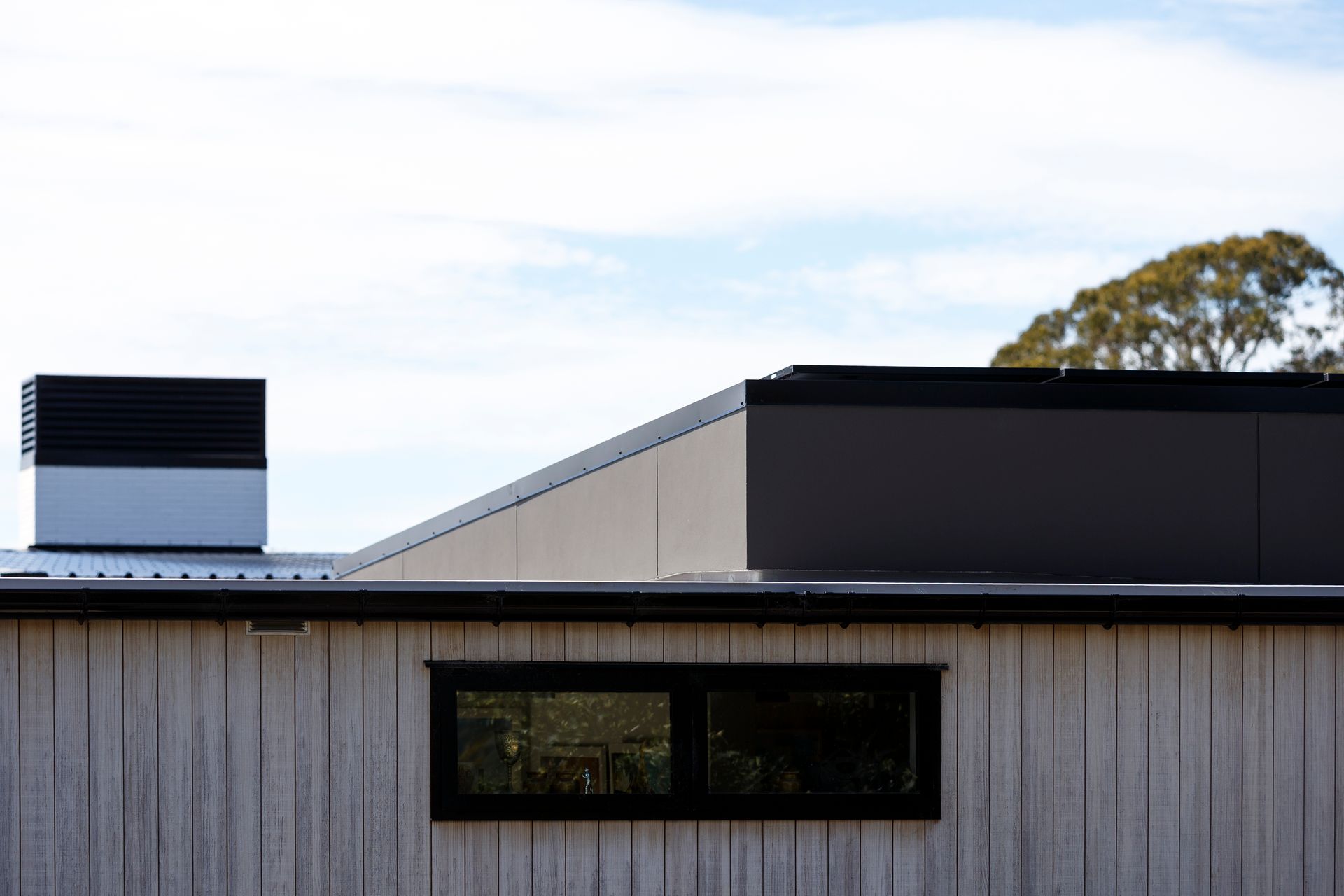 A house with a chimney on the roof and a window on the side.