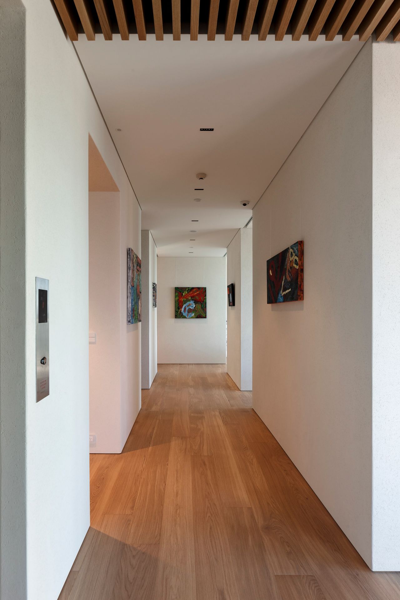A long hallway with wooden floors and white walls