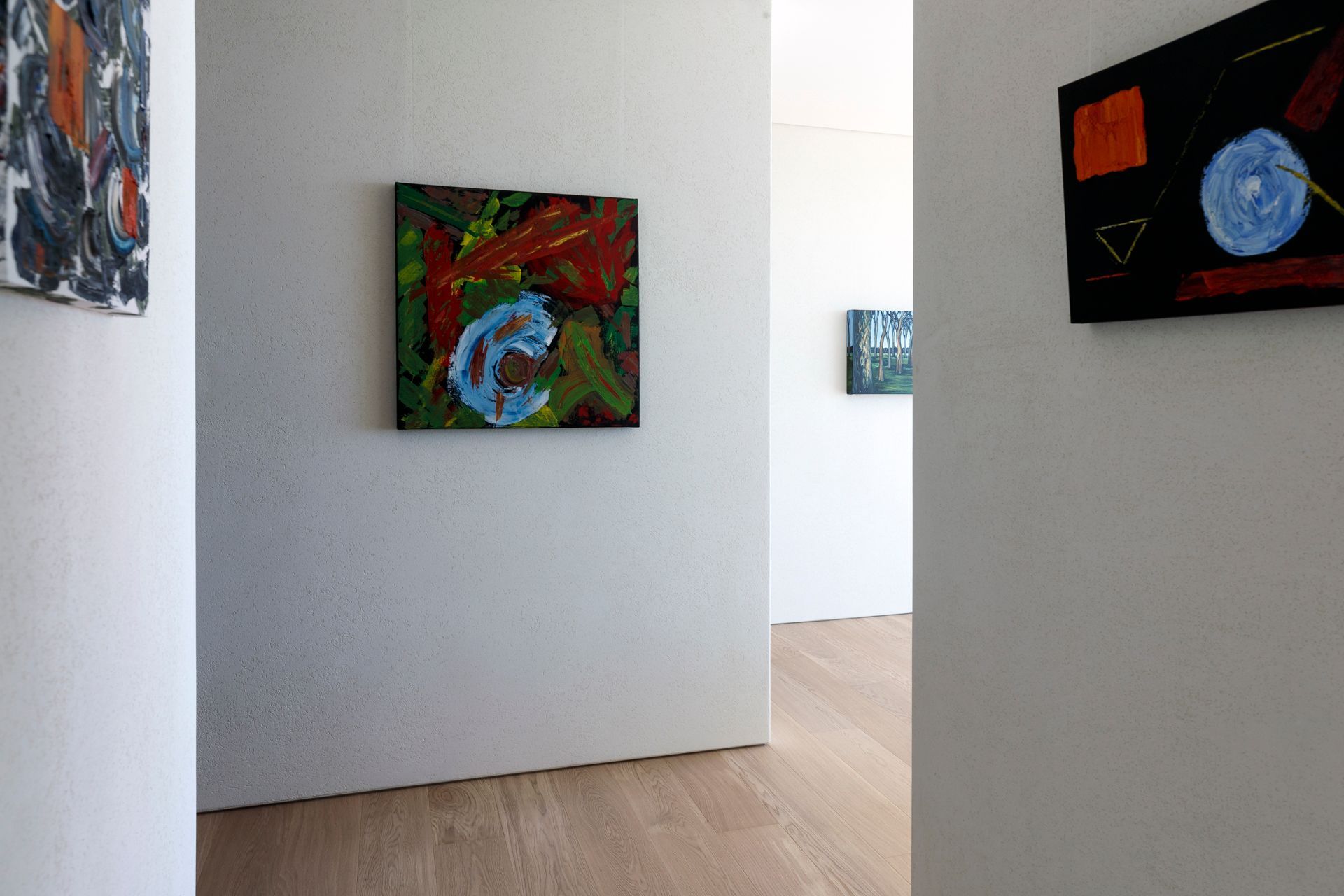 A hallway with paintings on the wall and a wooden floor