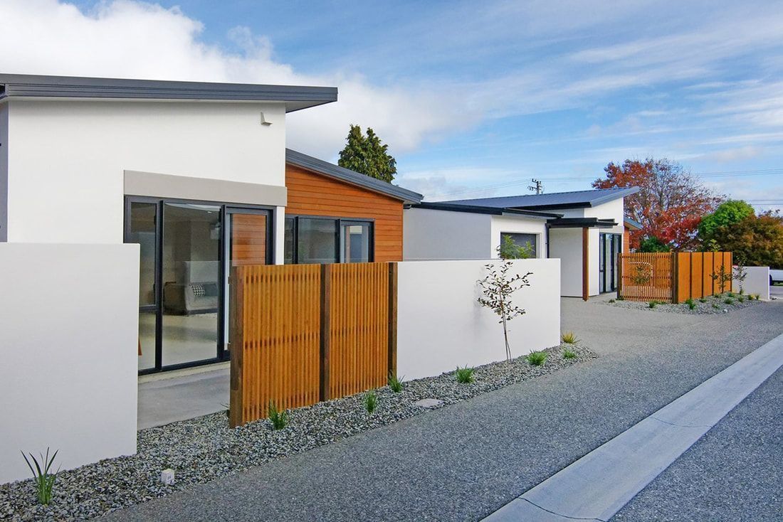 A row of houses with a wooden fence in front of them.