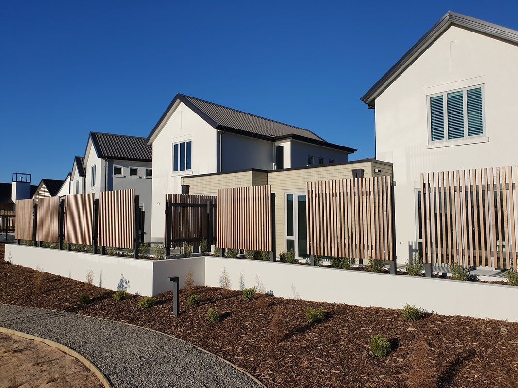 A row of houses with a wooden fence in front of them