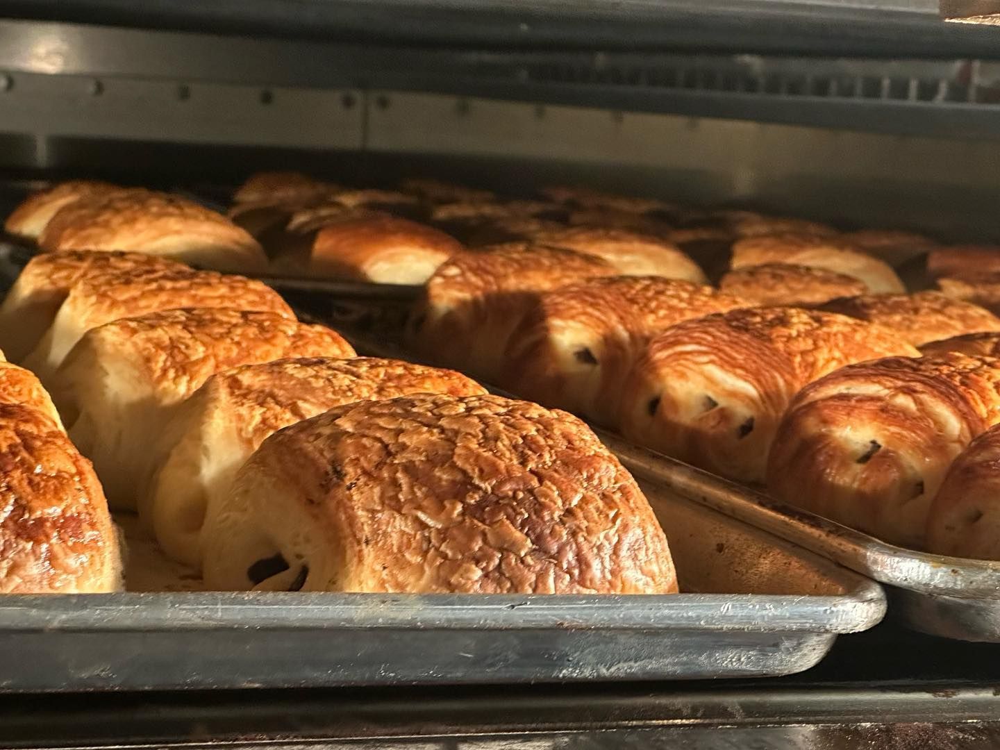 A bunch of pastries are sitting on a tray in an oven