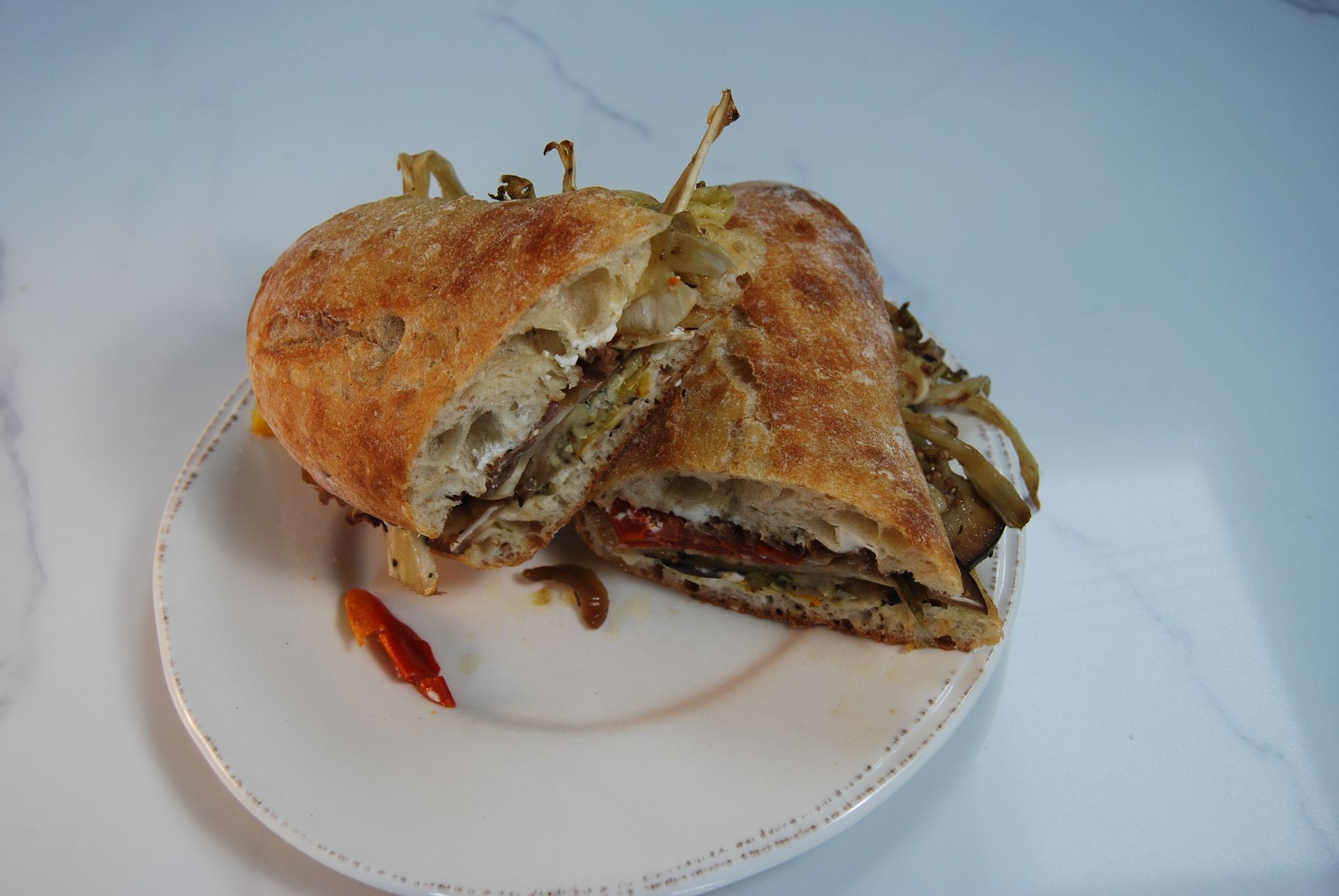 A sandwich is cut in half on a white plate