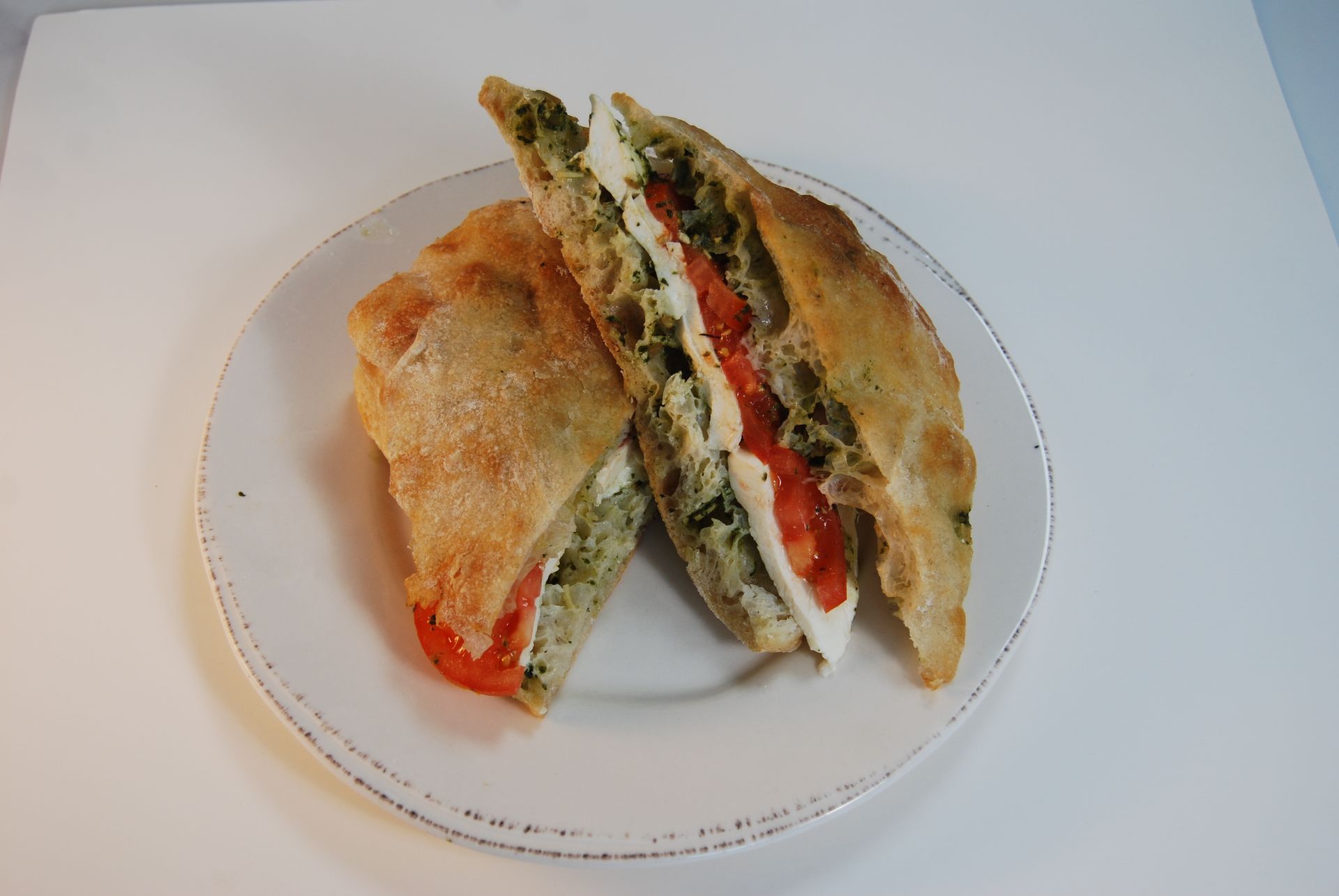 A white plate topped with a sandwich cut in half