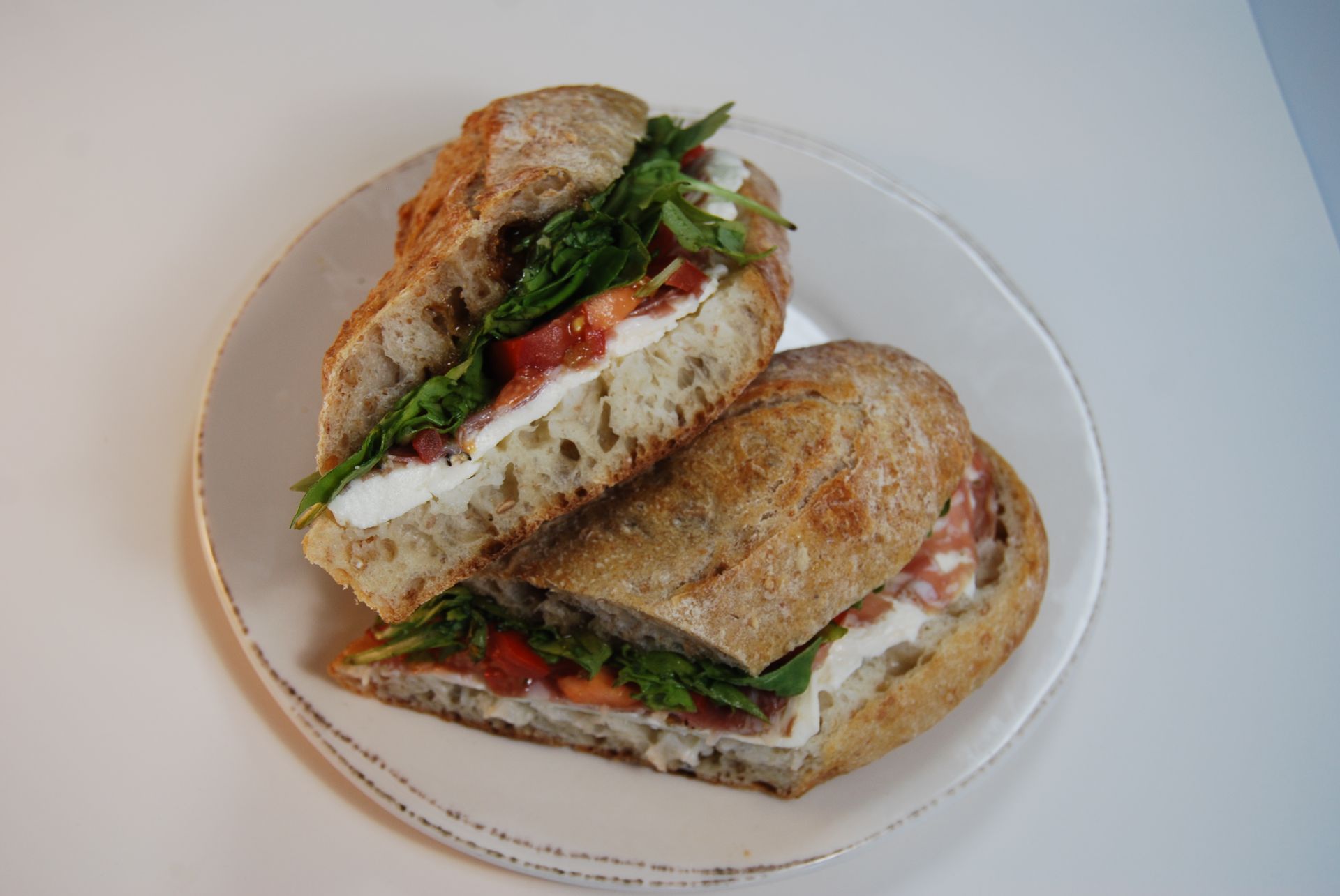 A sandwich is cut in half on a white plate