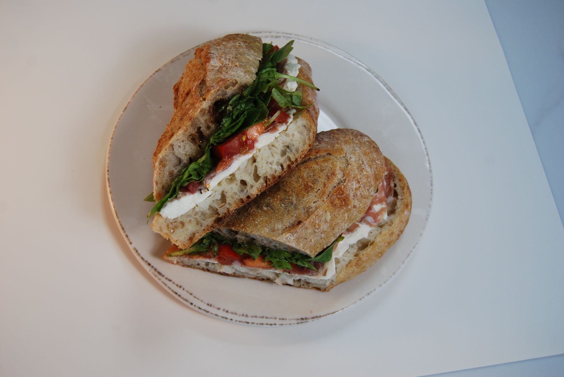 A sandwich is cut in half on a white plate