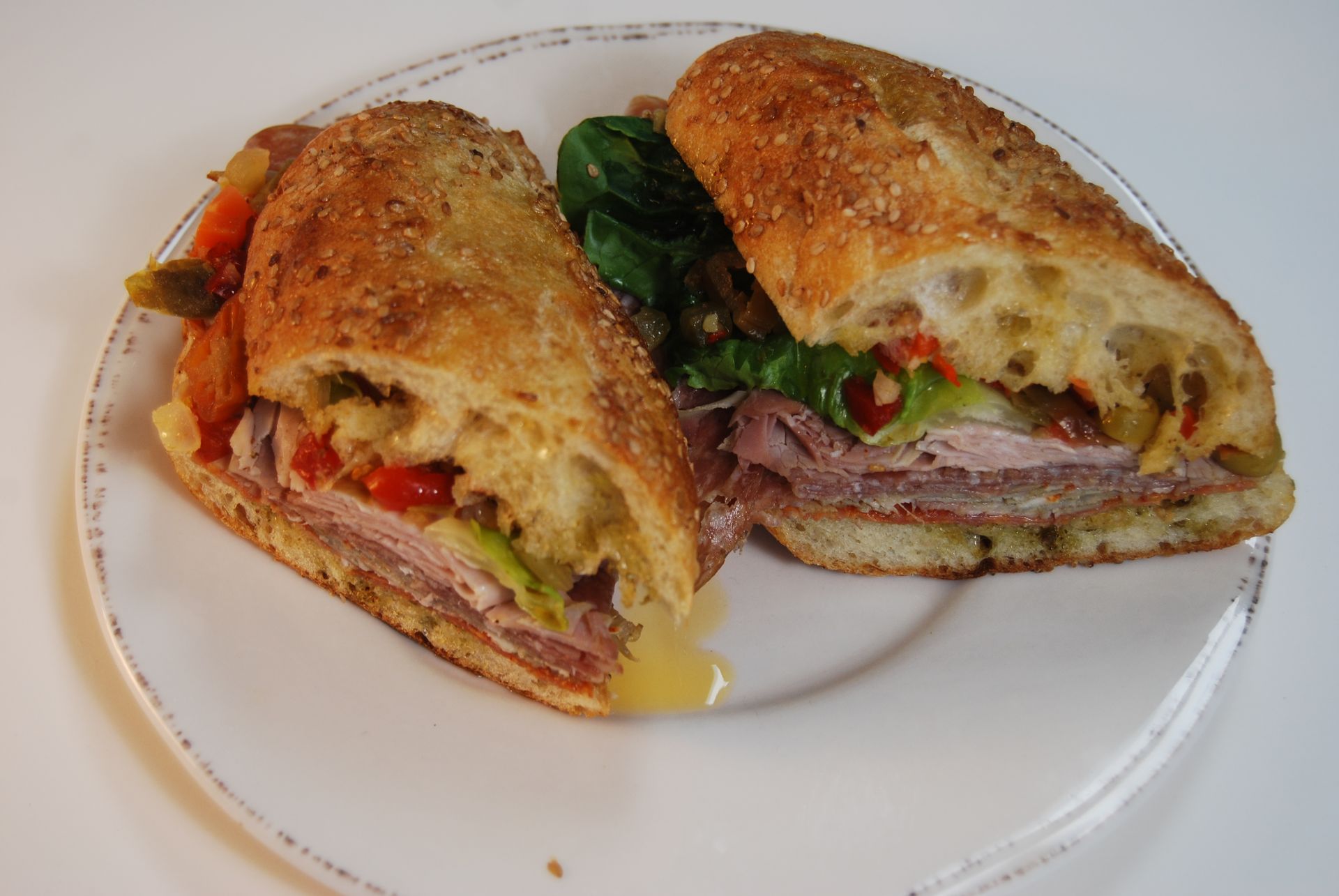 A sandwich is cut in half on a white plate