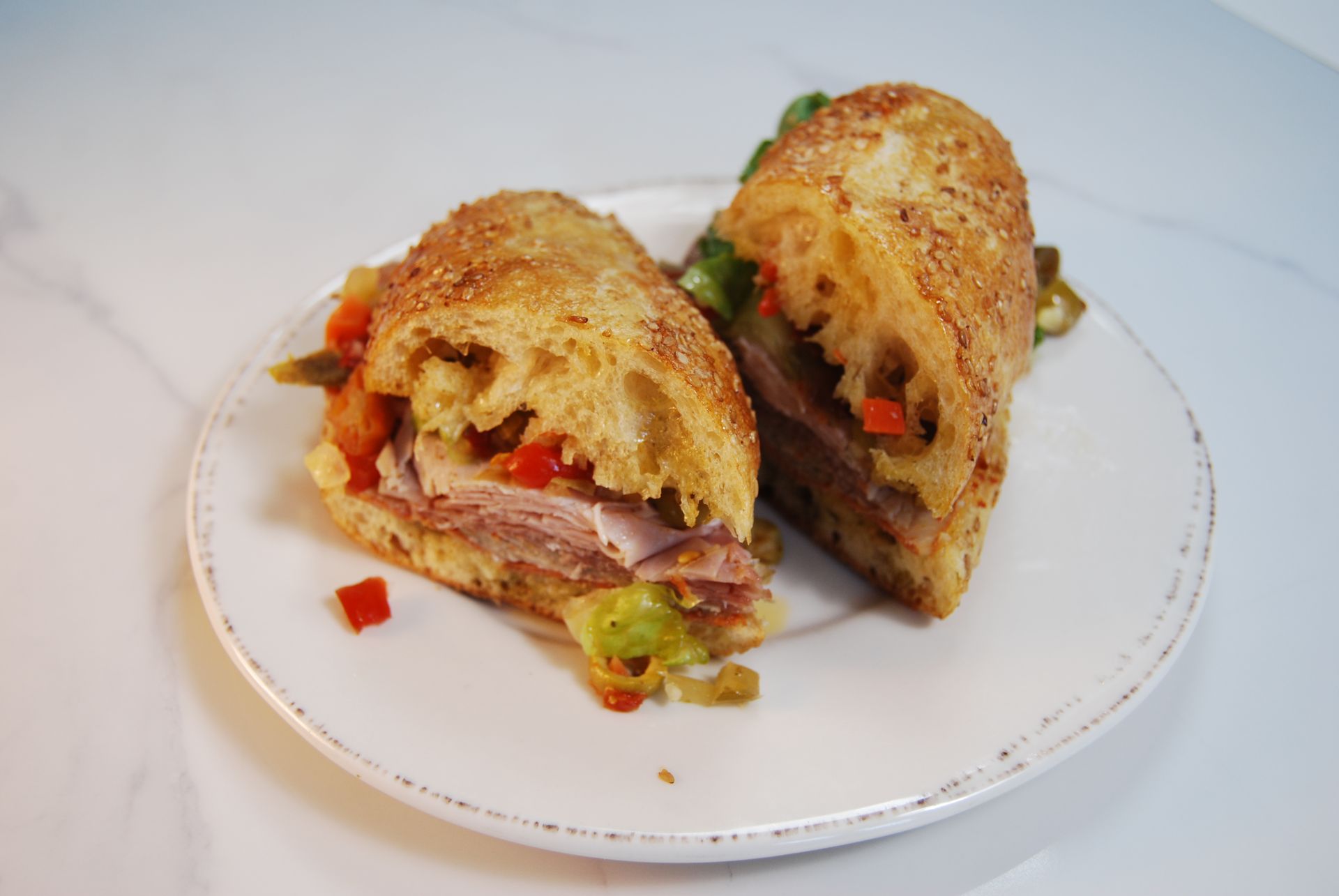 A sandwich is cut in half on a white plate