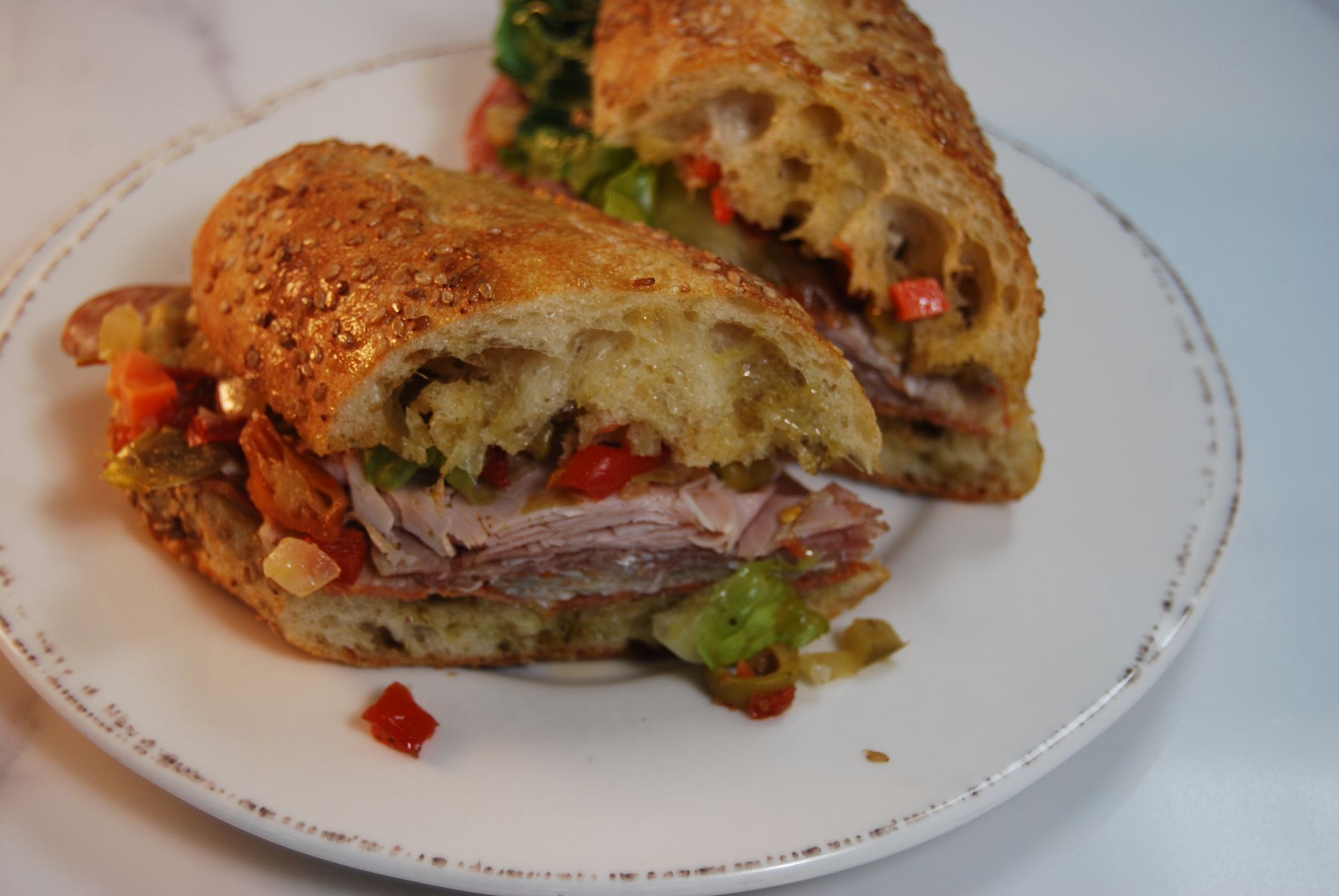 A sandwich is cut in half on a white plate