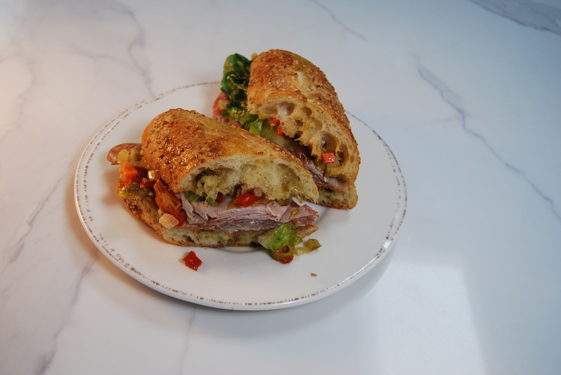 A sandwich is cut in half on a white plate