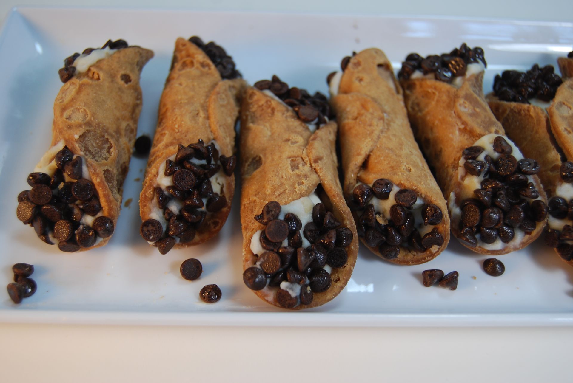 A tray of cannoli with chocolate chips on top