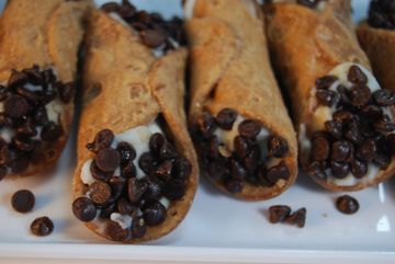 A tray of cannoli with chocolate chips on top