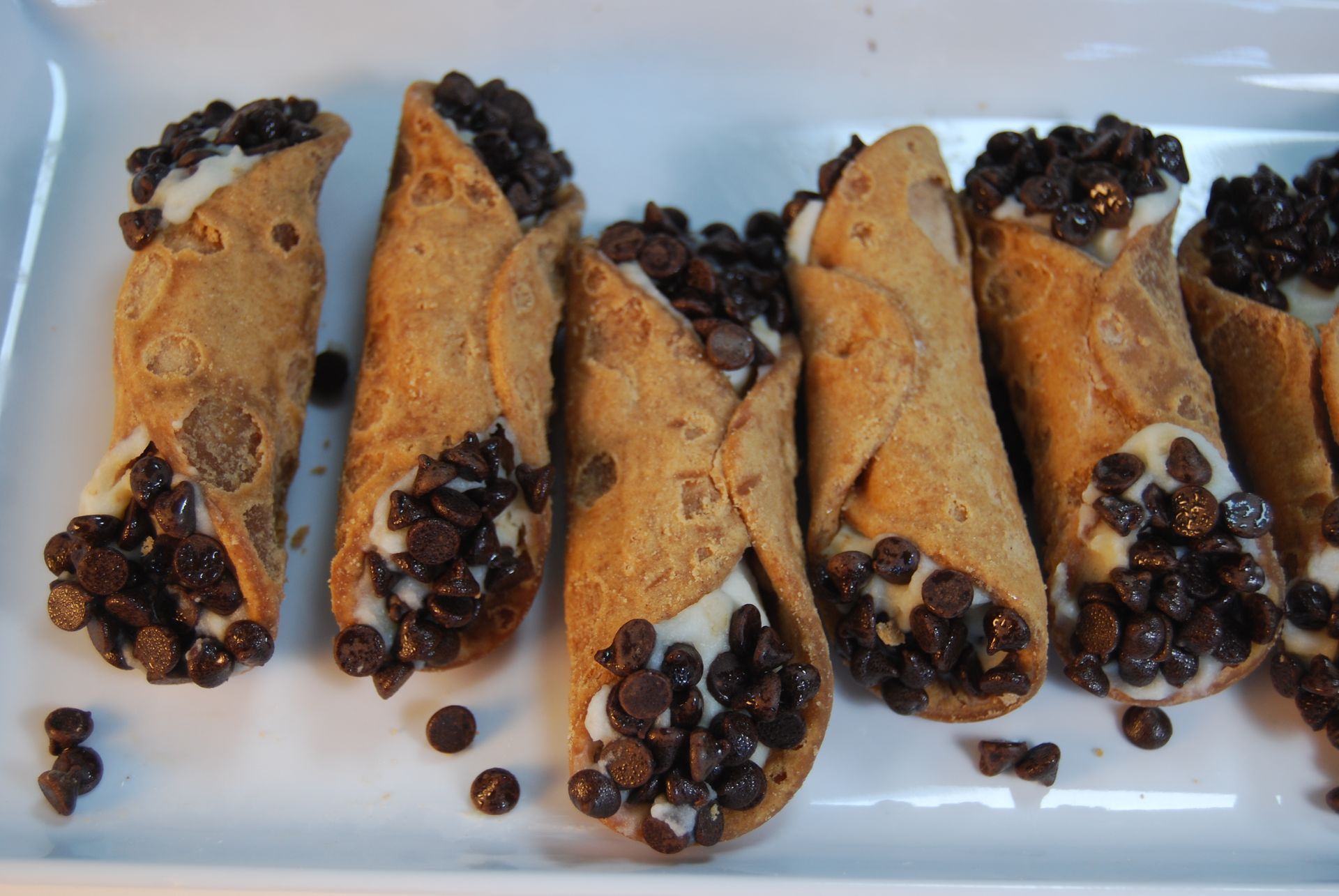 A tray of cannoli with chocolate chips on top