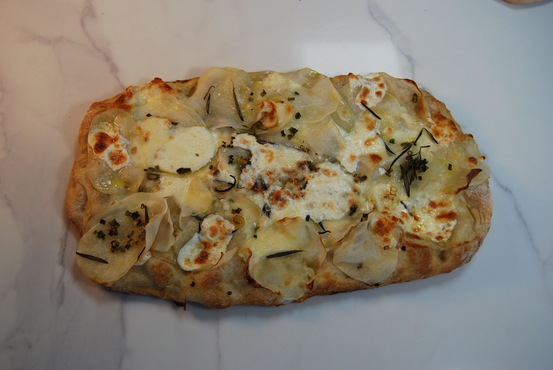 A pizza with a lot of cheese and potatoes on it