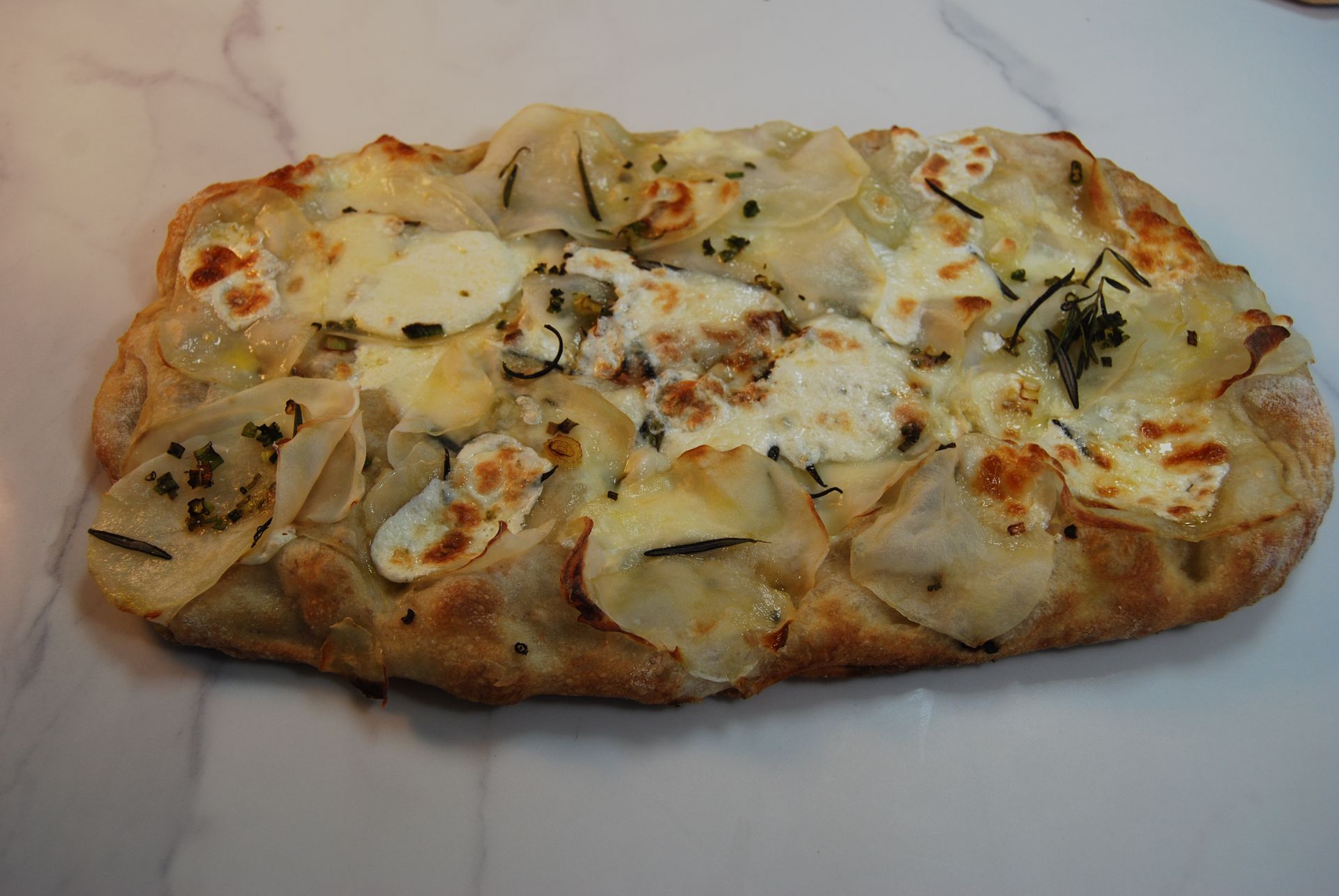 A pizza with a lot of cheese and potatoes on it