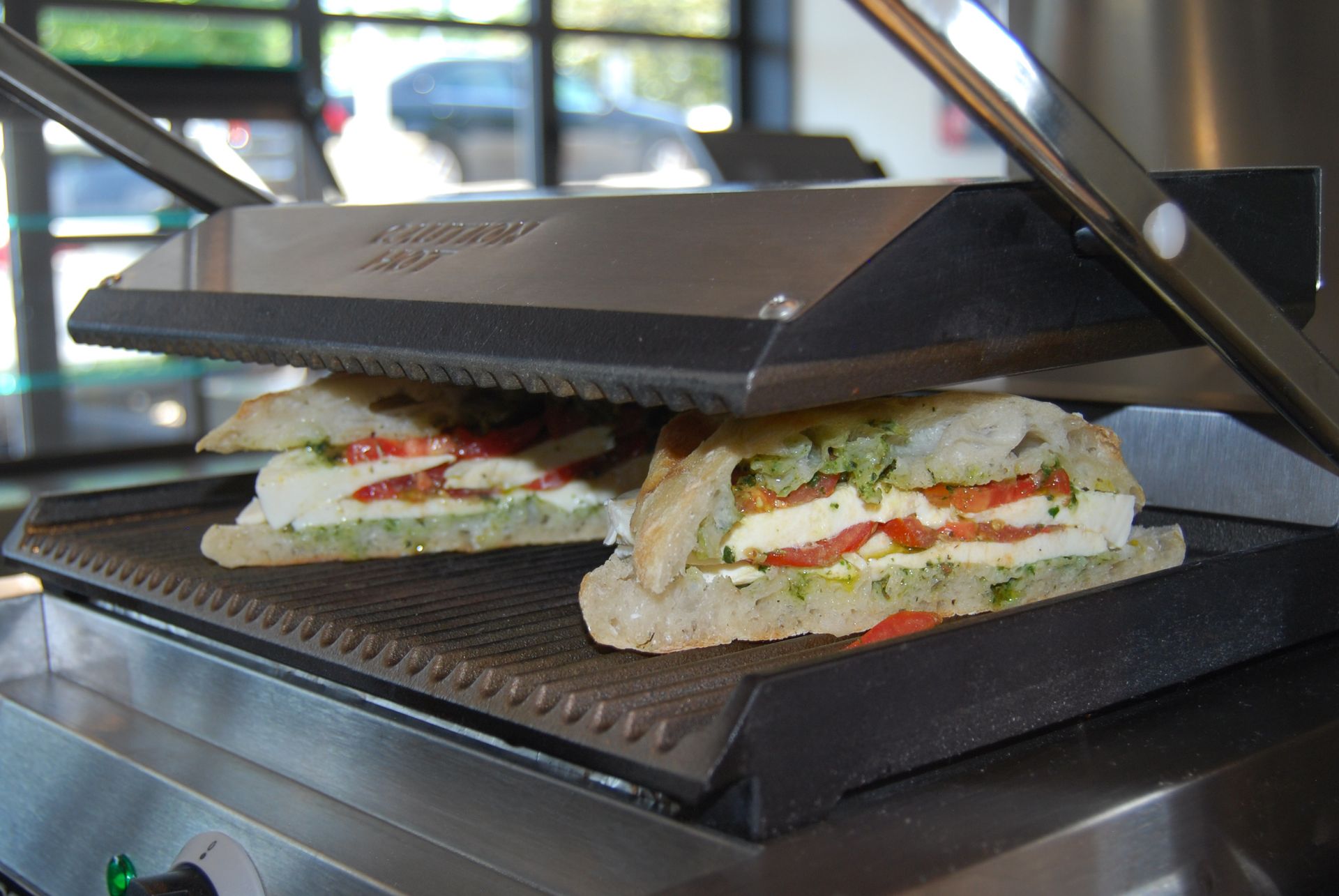 A sandwich is being cooked on a grill with a green light on it