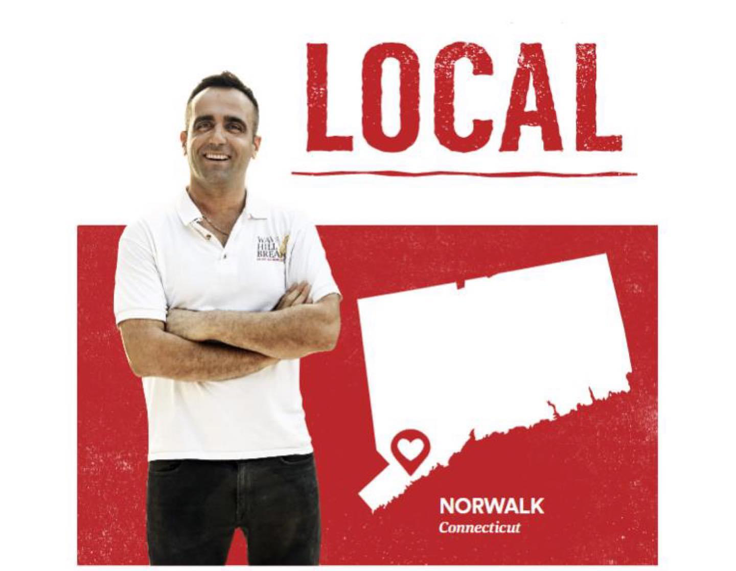 A man is standing in front of a sign that says local