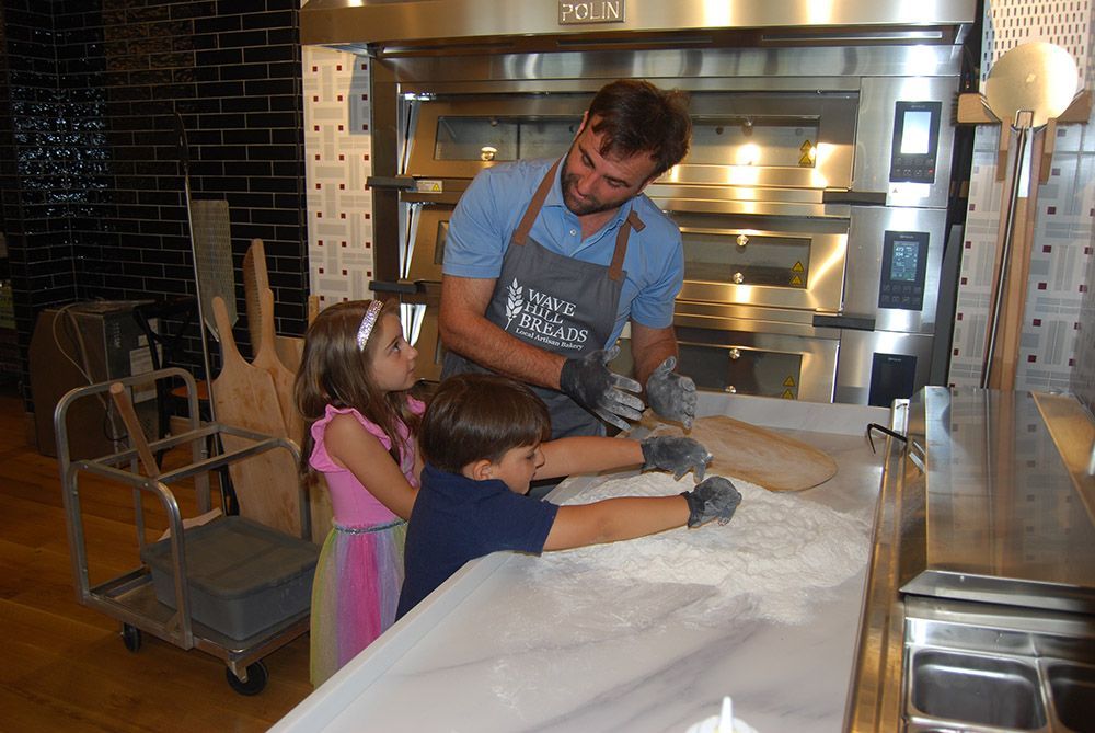 A man wearing an apron that says ' baker ' on it