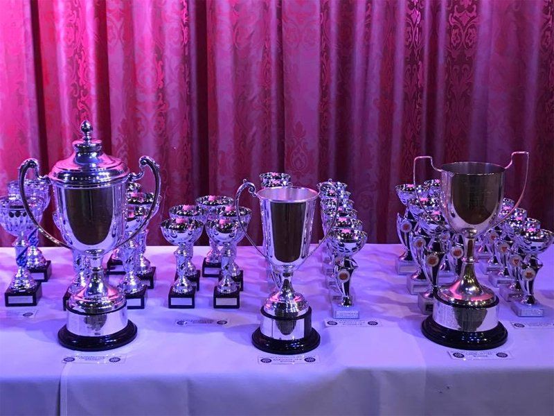 Range of engraved trophies on a table at ceremony