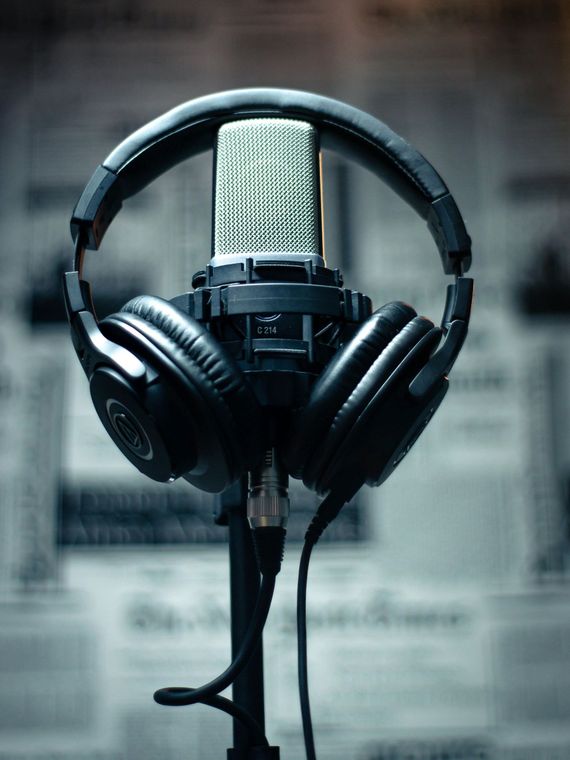 A pair of headphones sitting on top of a microphone on a stand.