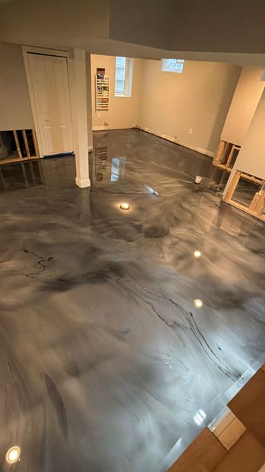 Worker boots walking across a glossy blue epoxy floor in a room under construction