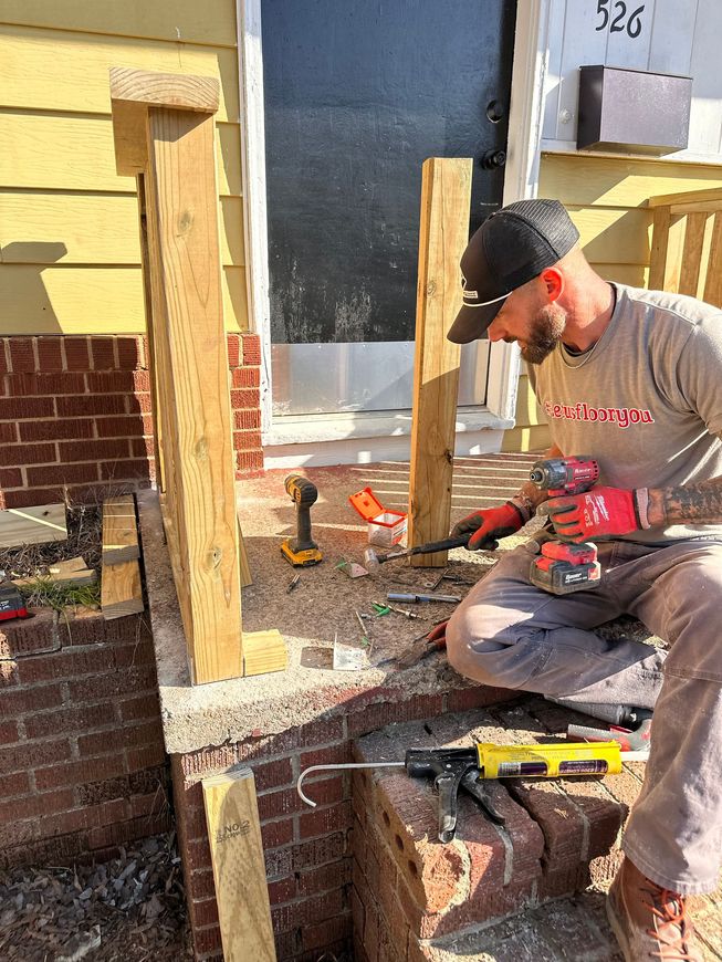 Carpenter measuring and marking wood on a wooden wall, using a measuring tape.