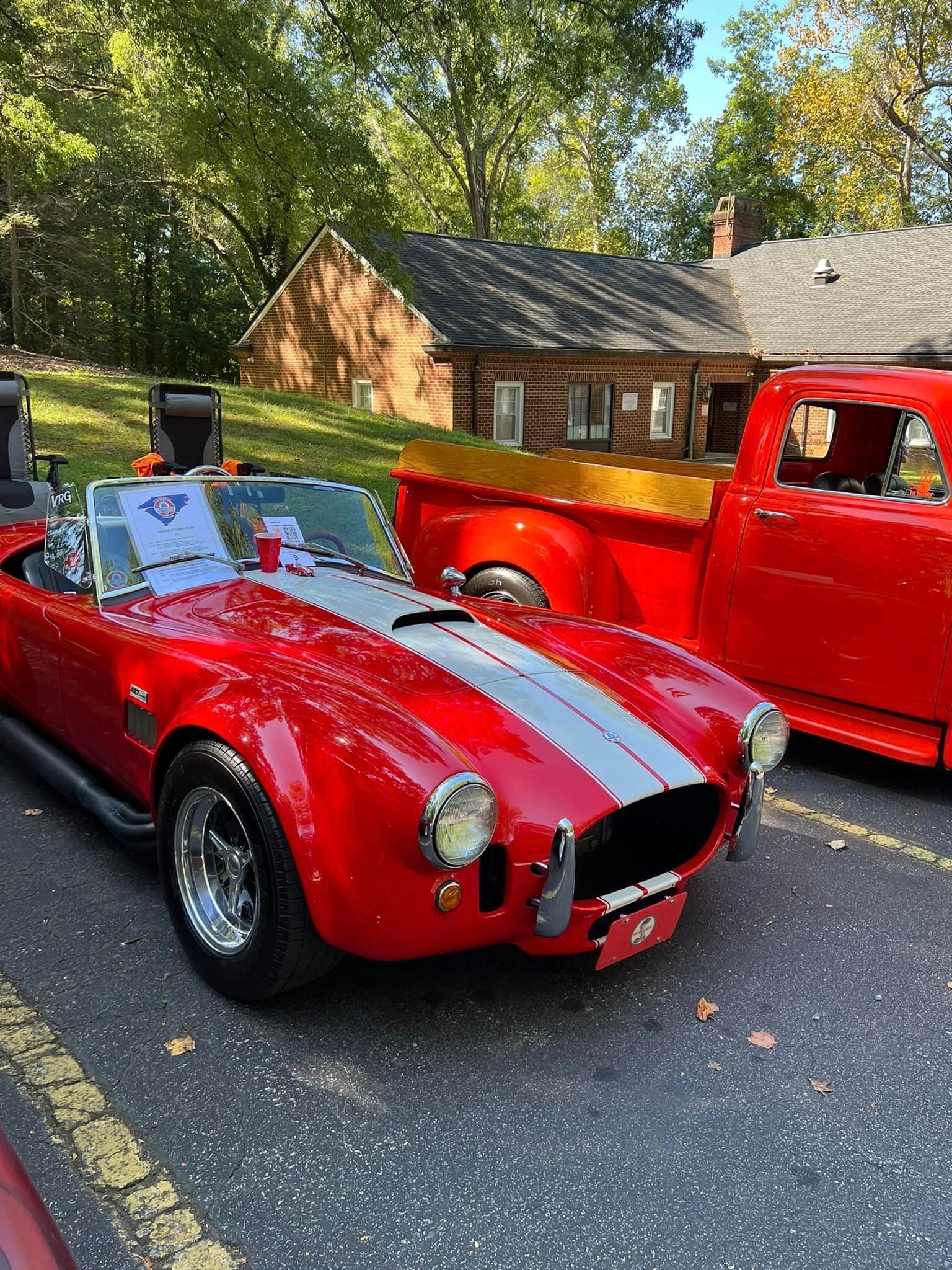 Classic red sports car and antique red truck