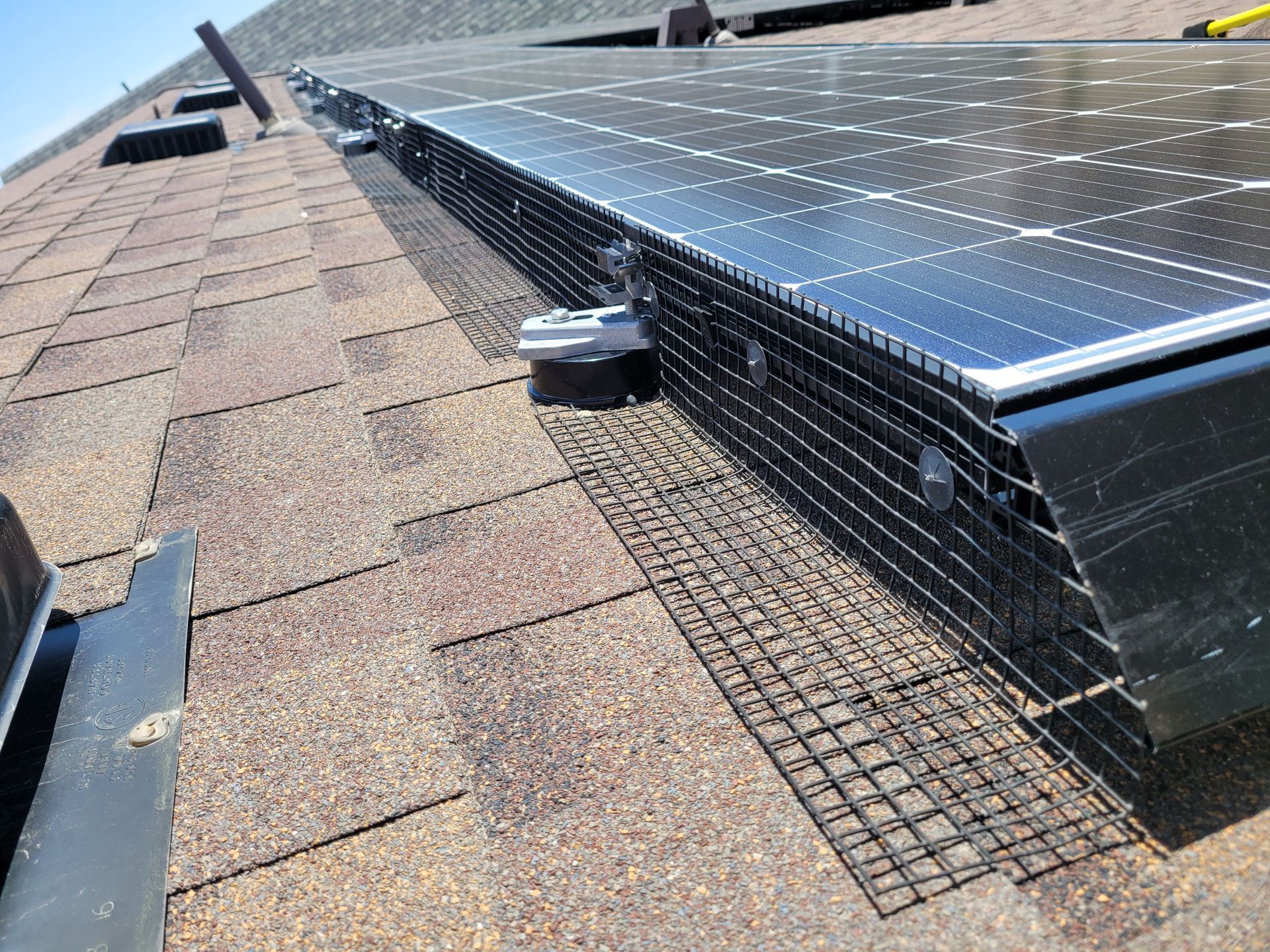 A row of solar panels are sitting on top of a roof.