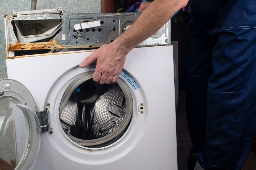 Technician Repairing Washing Machine