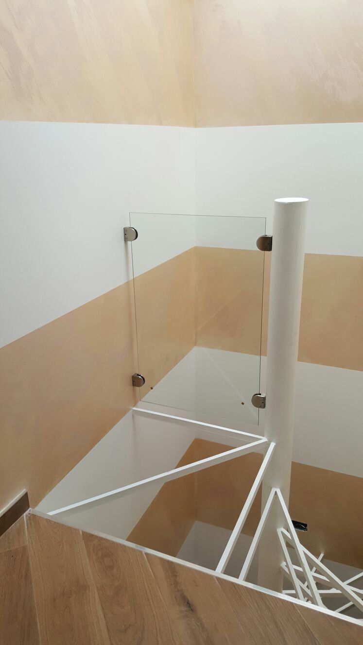 scala a chiocciola in costruzione con balaustra di vetro