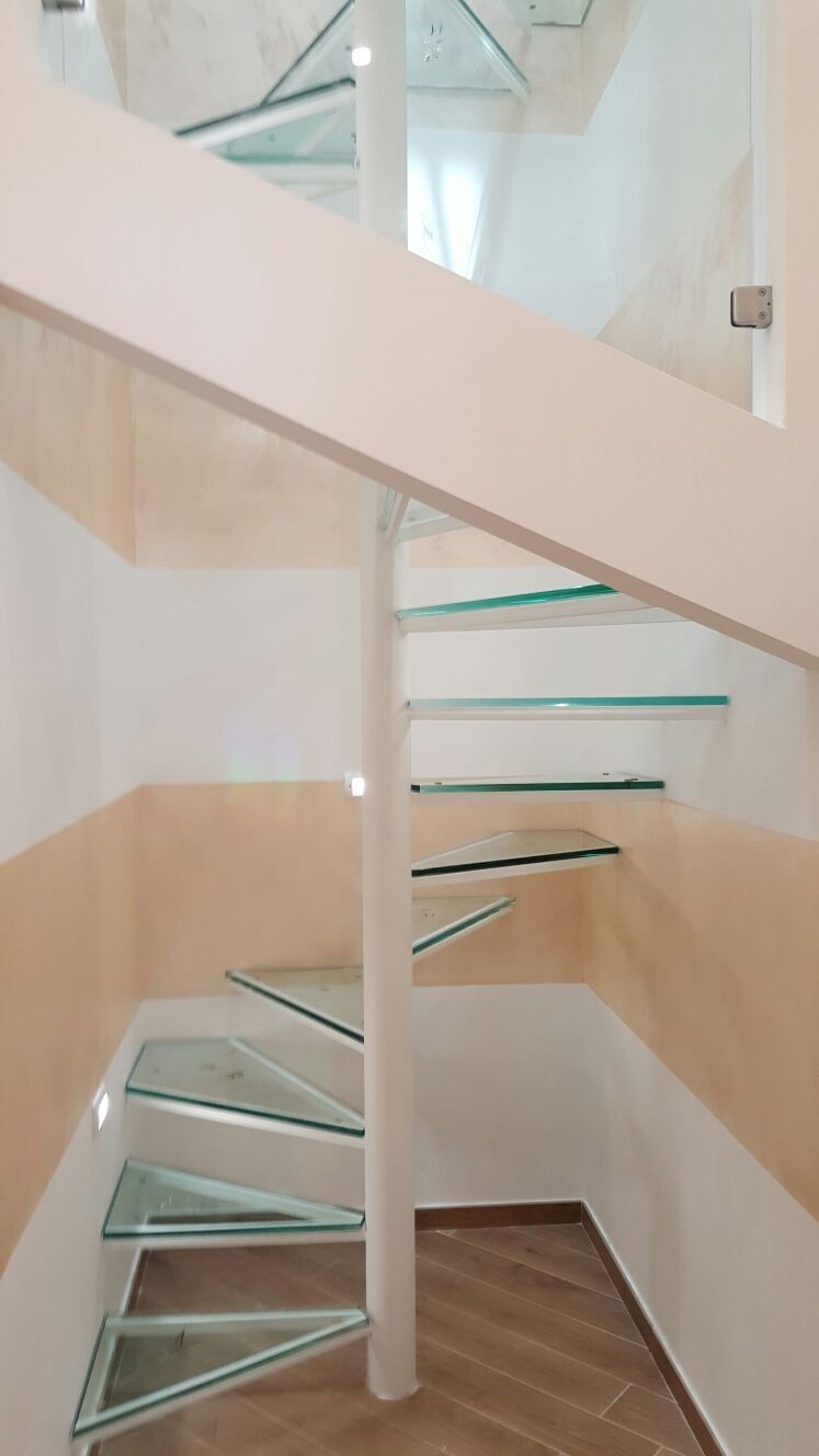 corridoio con scale a chiocciola in vetro