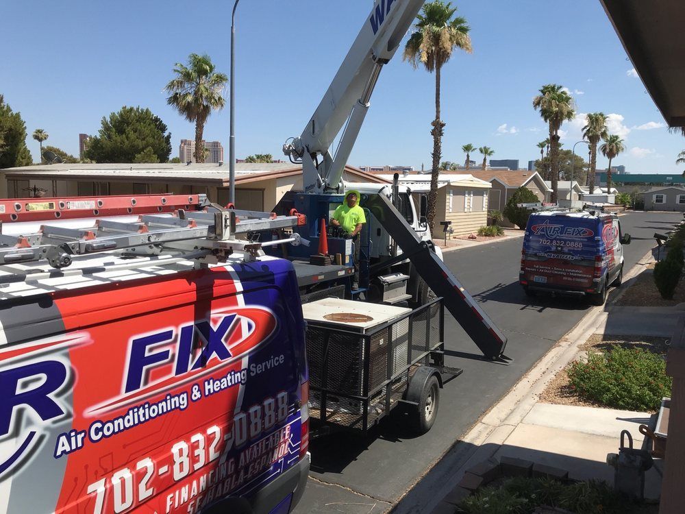 HVAC service trucks on a street, a worker in a lift, and equipment are visible.