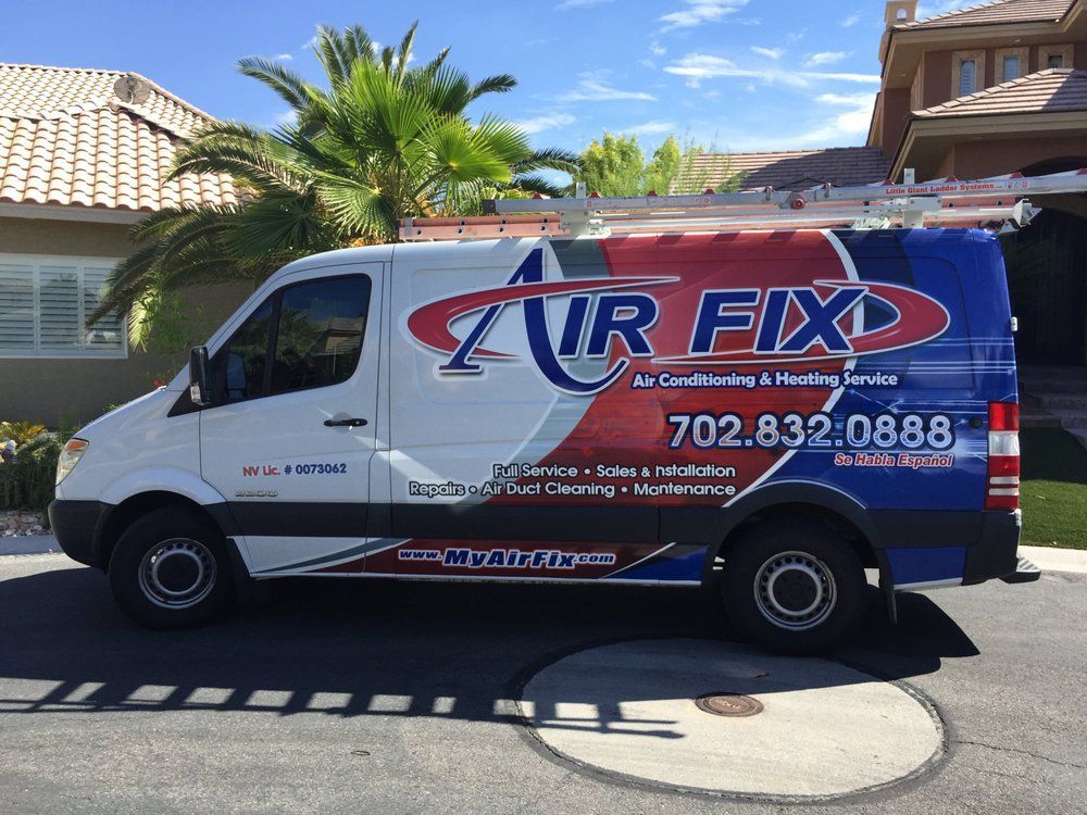 White Air Fix van parked on street; company logo and phone number on side.