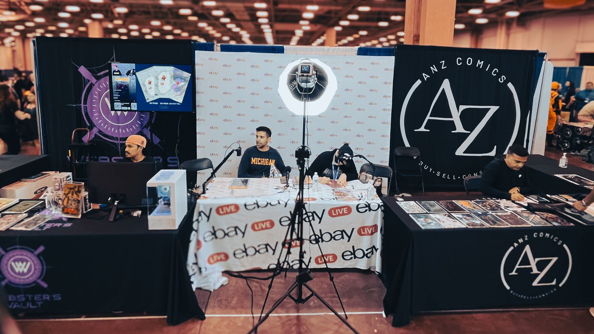 A AnZ Comics team sitting at a table in front of a microphone at Dallas Fan Fest 2024.