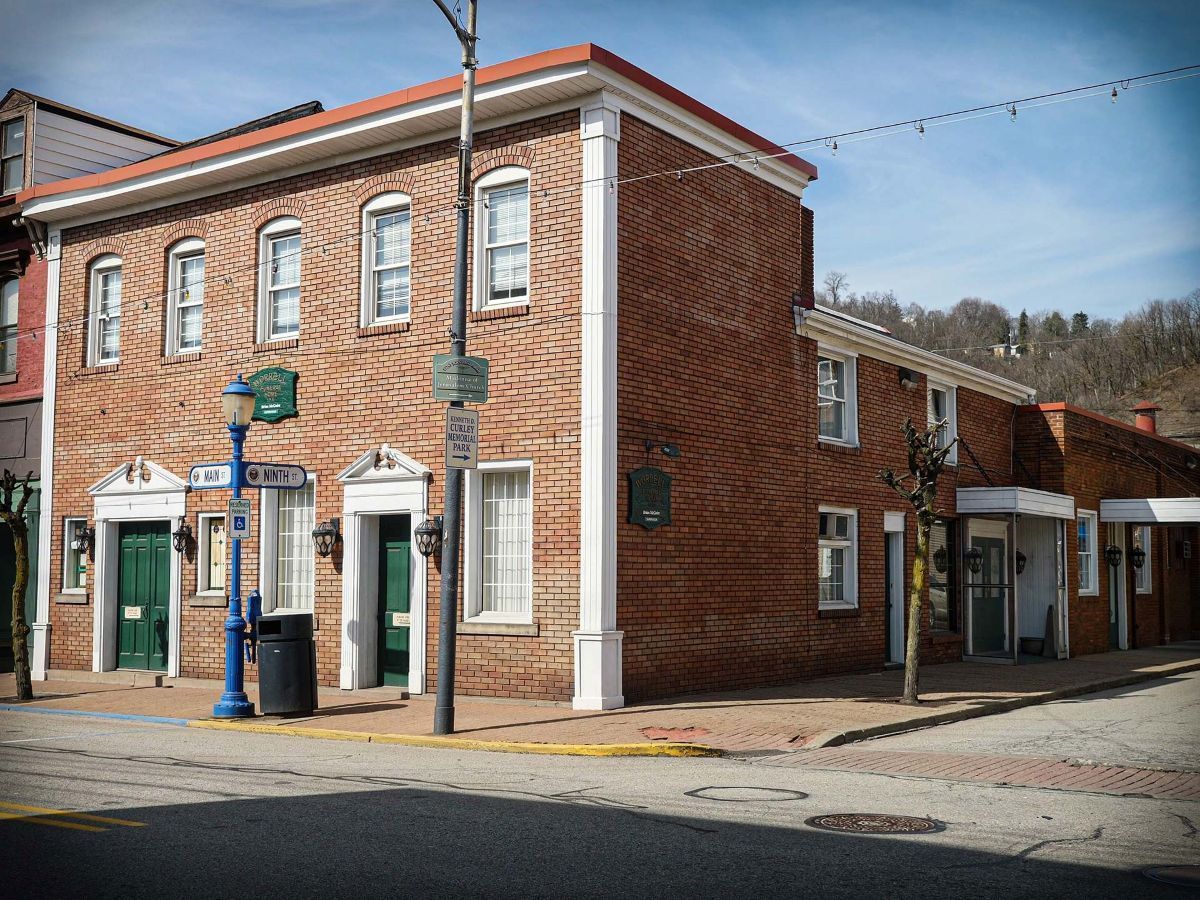 A large white building with a brown roof and a lot of windows.