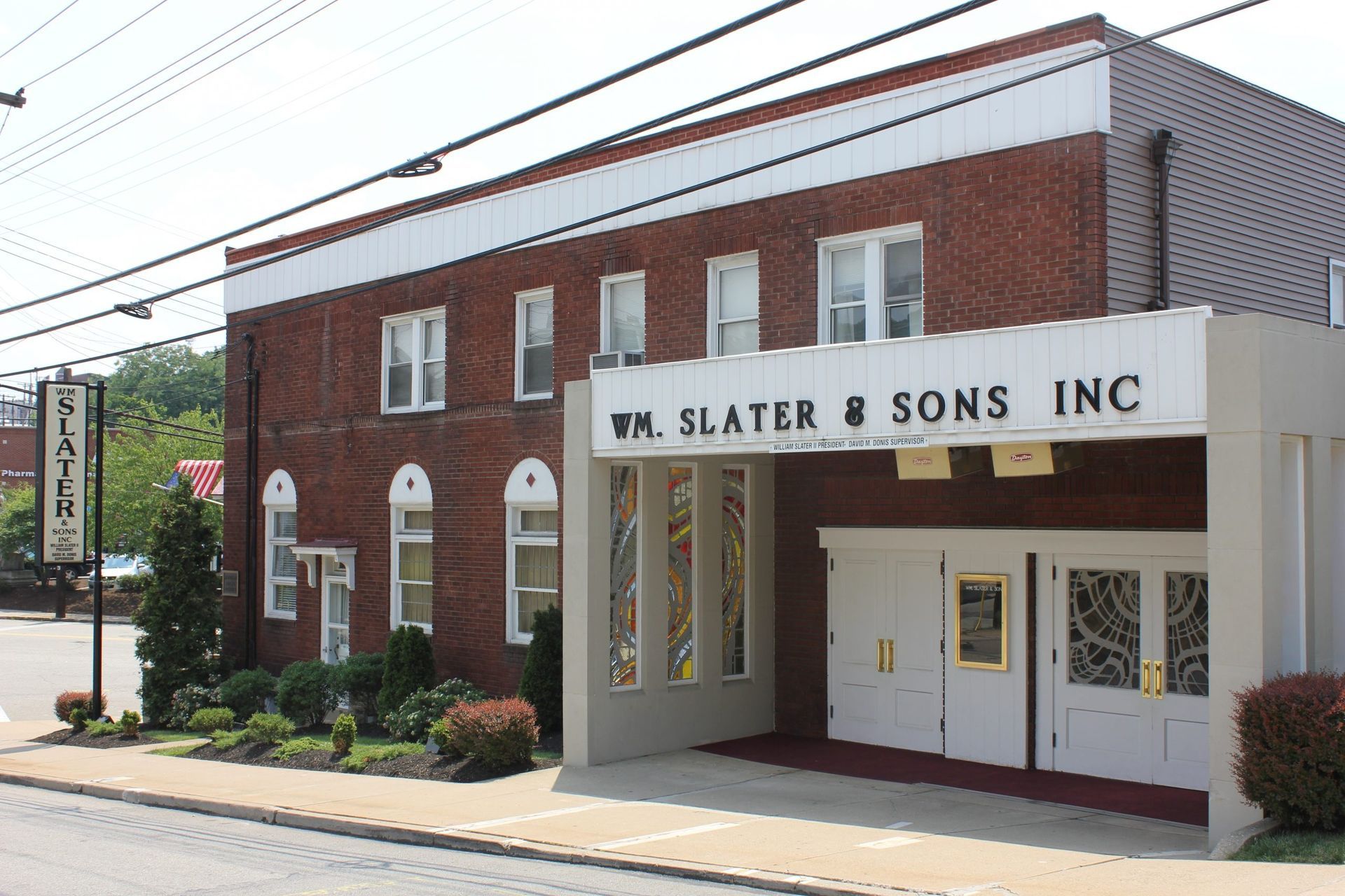 A large white building with a brown roof and a lot of windows.