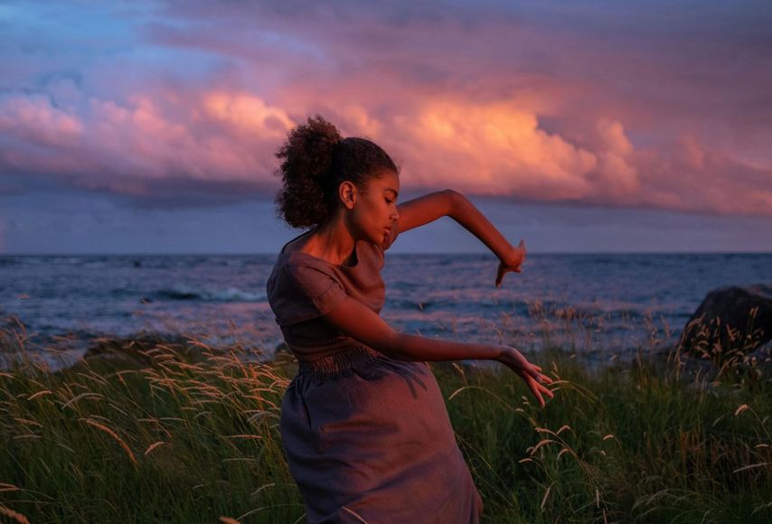 woman seated in the desert with  hands on heart and belly