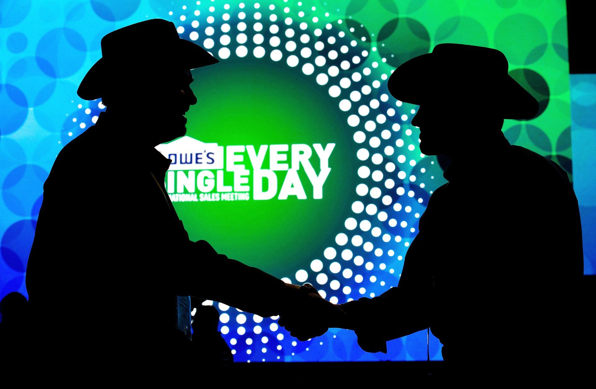 Dramatic silhouette of men shaking hands on stage