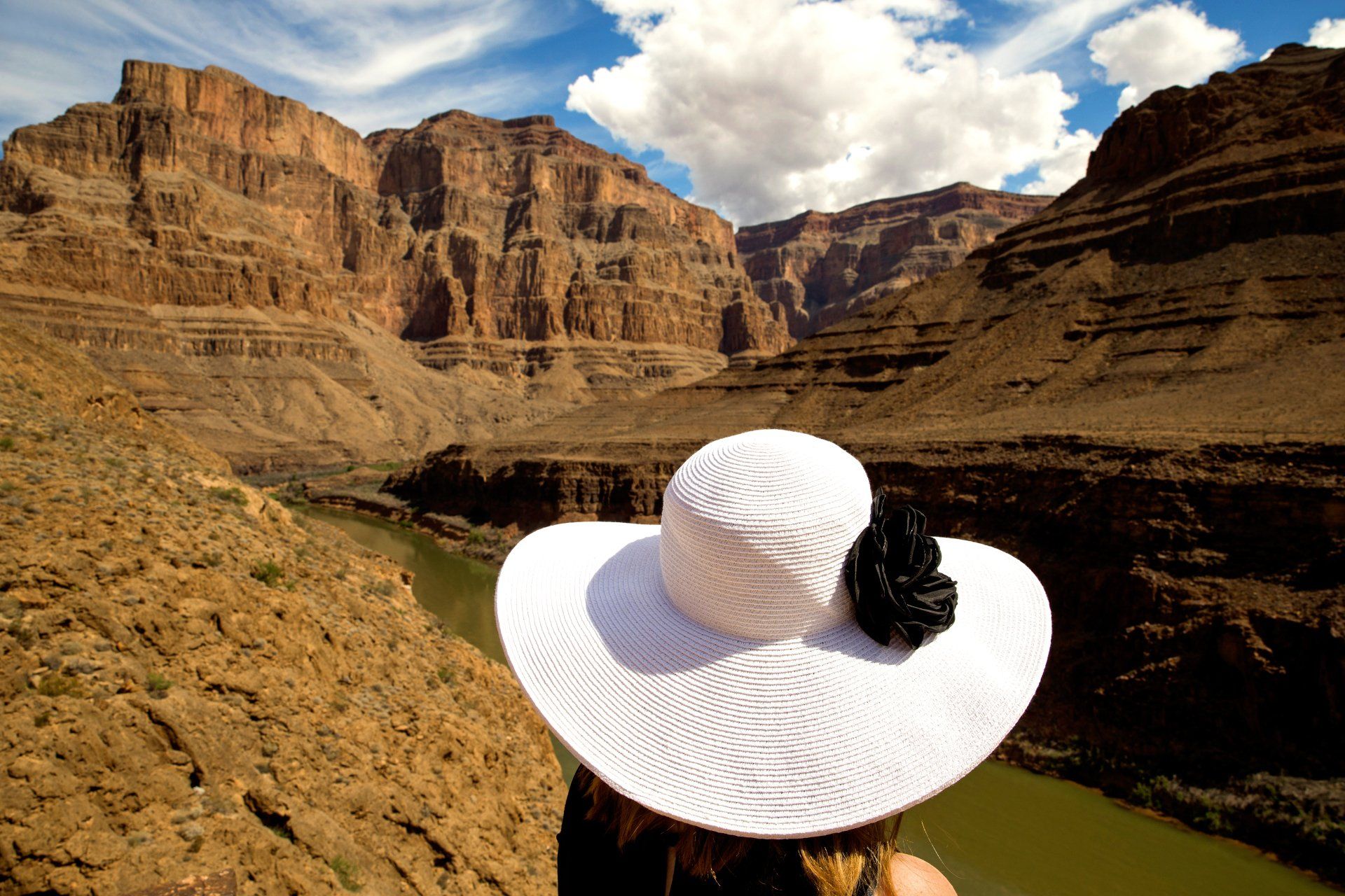 A company employees relaxes with a view across a dramatic western canyon during a company trip